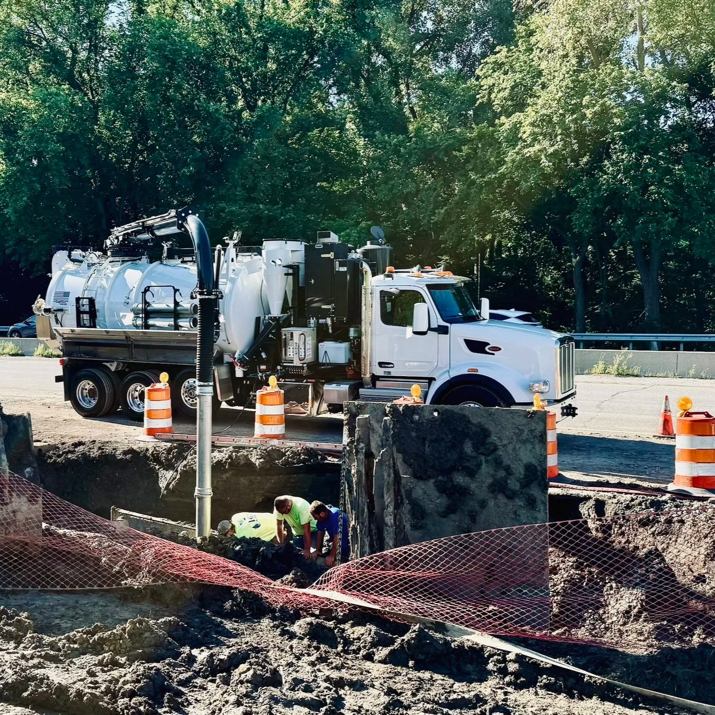 Workers or engineers at a construction site working near a large trench, with a GapVax vacuum truck doing bore support as they work to install a new gas pipeline in Crestwood, KY/