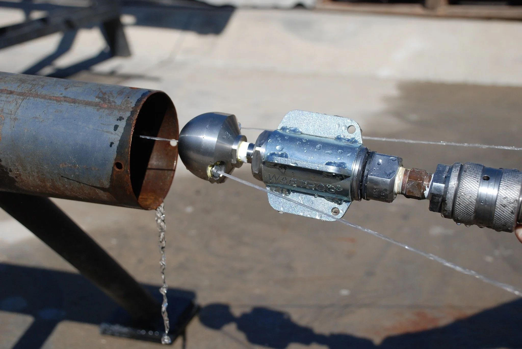 Warthog sewer nozzle sold by 502 Equipment spraying water out of the front end to demonstrate its powerful jets.