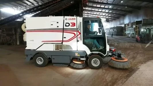 A Dulevo D3 industrial sweeper inside a large industrial warehouse in Indiana cleaning up dust with the mechanical suction technology on board.
