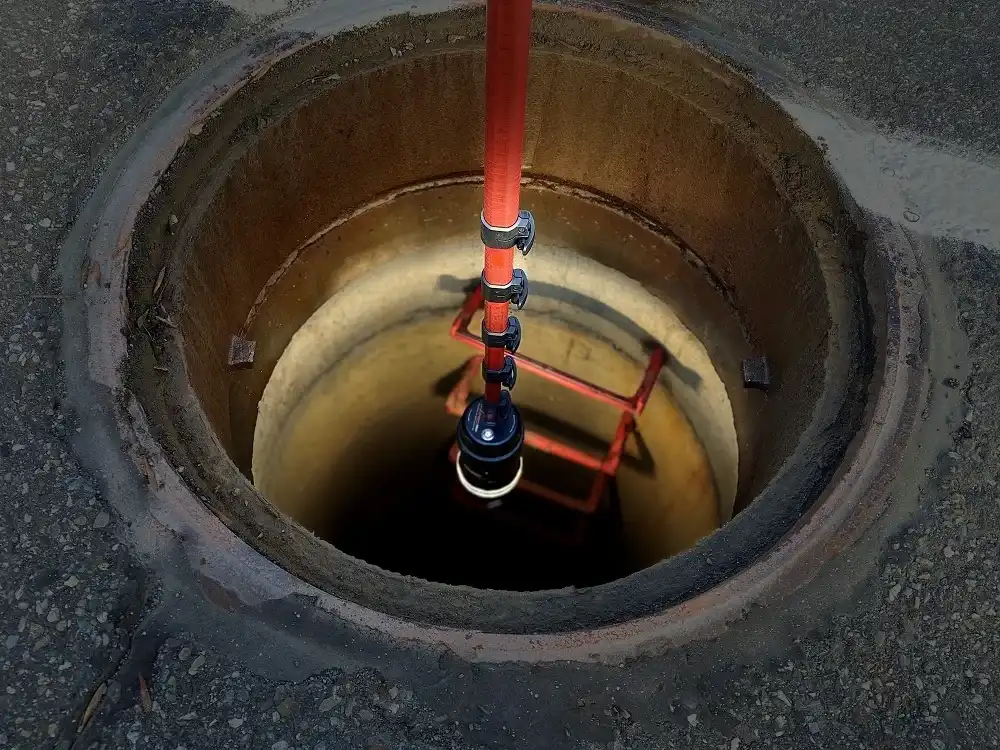 Rinnovision RV max 360 degree manhole inspection camera looking down into a manhole with a red extension pole and a safety ladder inside.