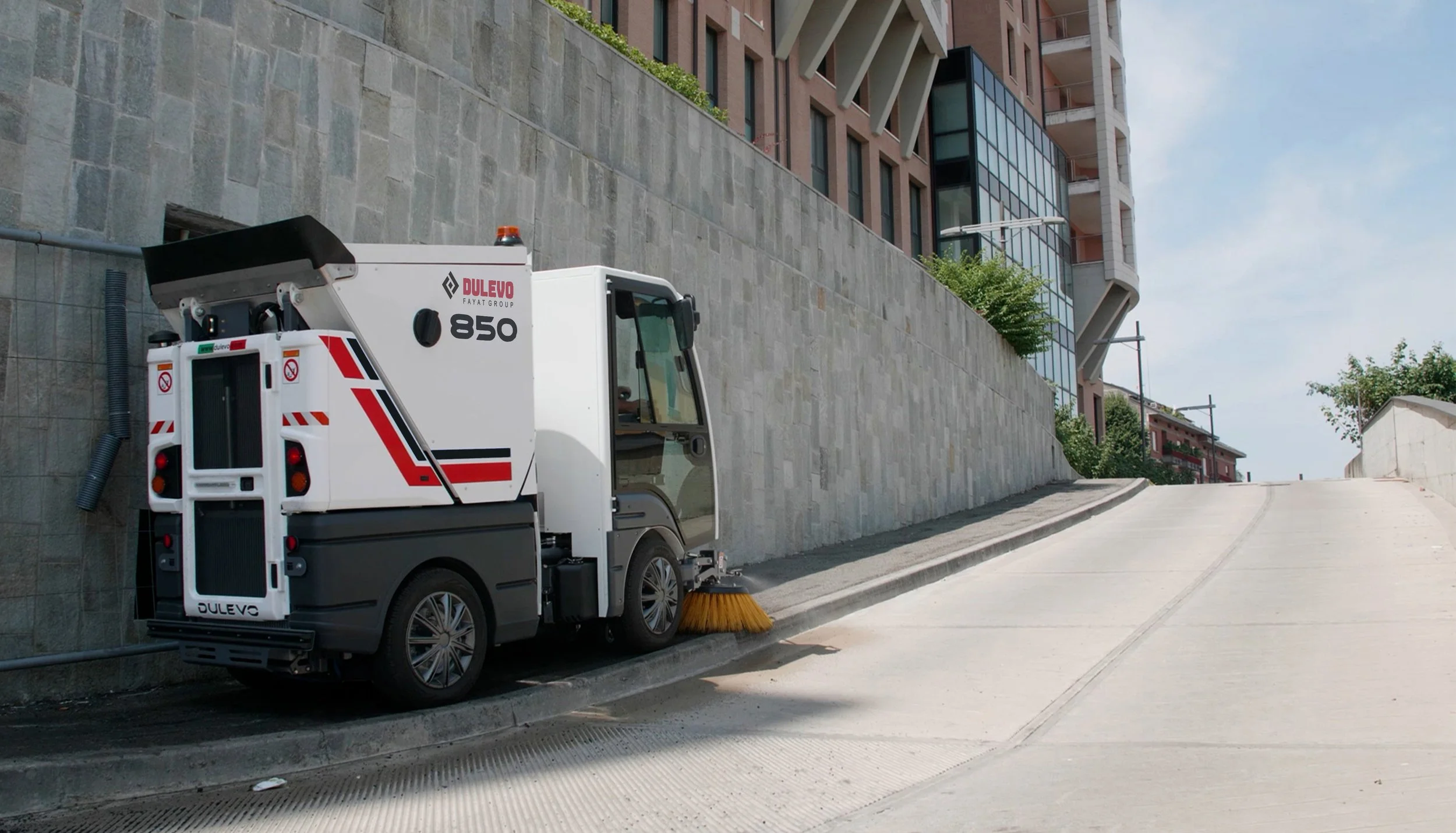 A dulevo 850 compact street sweeper cleaning city sidewalk near building in Nashville, Tennessee.