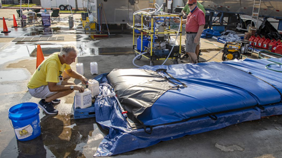 Two men activating a mobile water treatment system water tank,  in Western, Kentucky.
