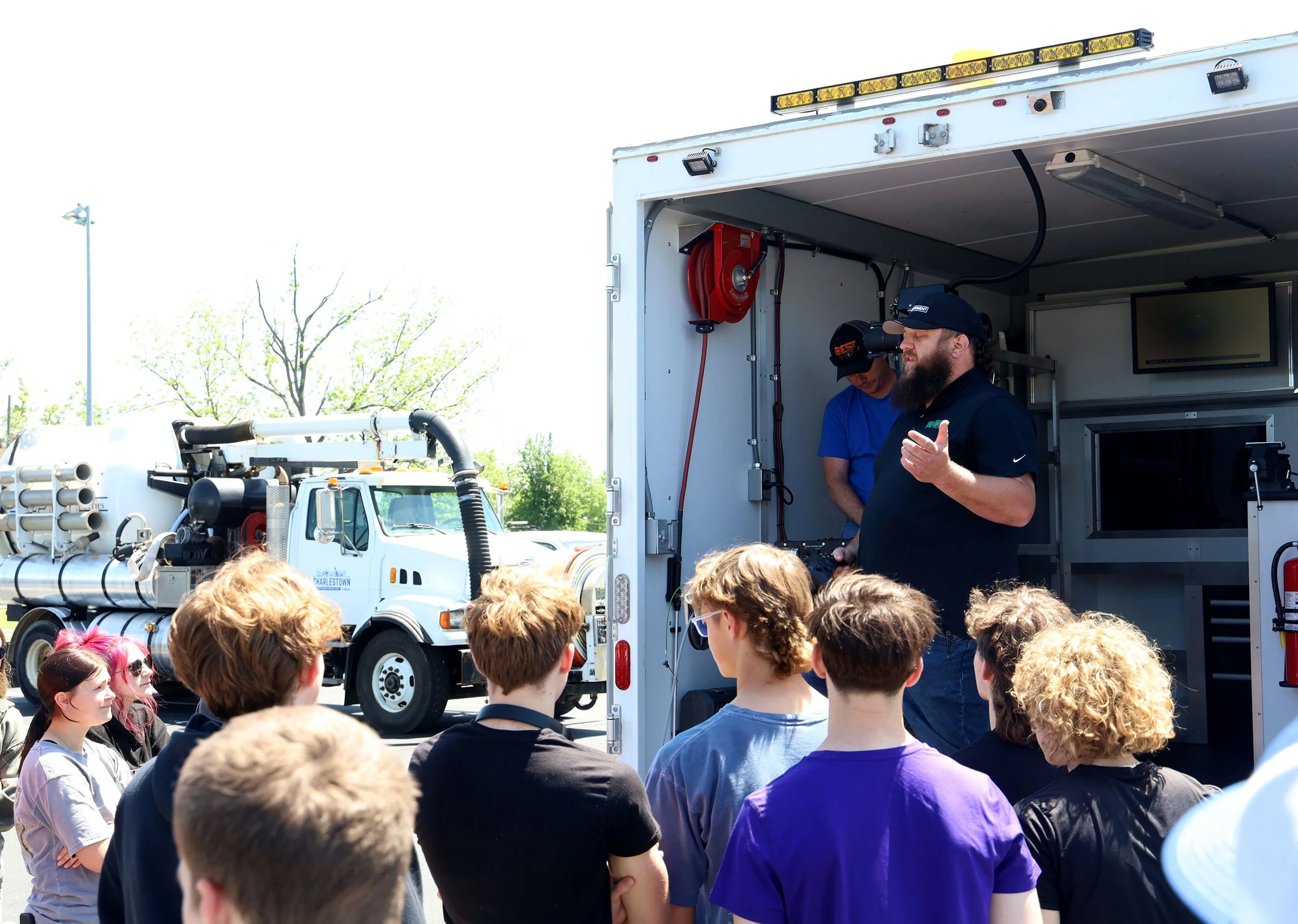 A group watching a dylan martin giving a presentation at Charlestown, Indiana about Aries voyager mainline inspection system on a sunny day.