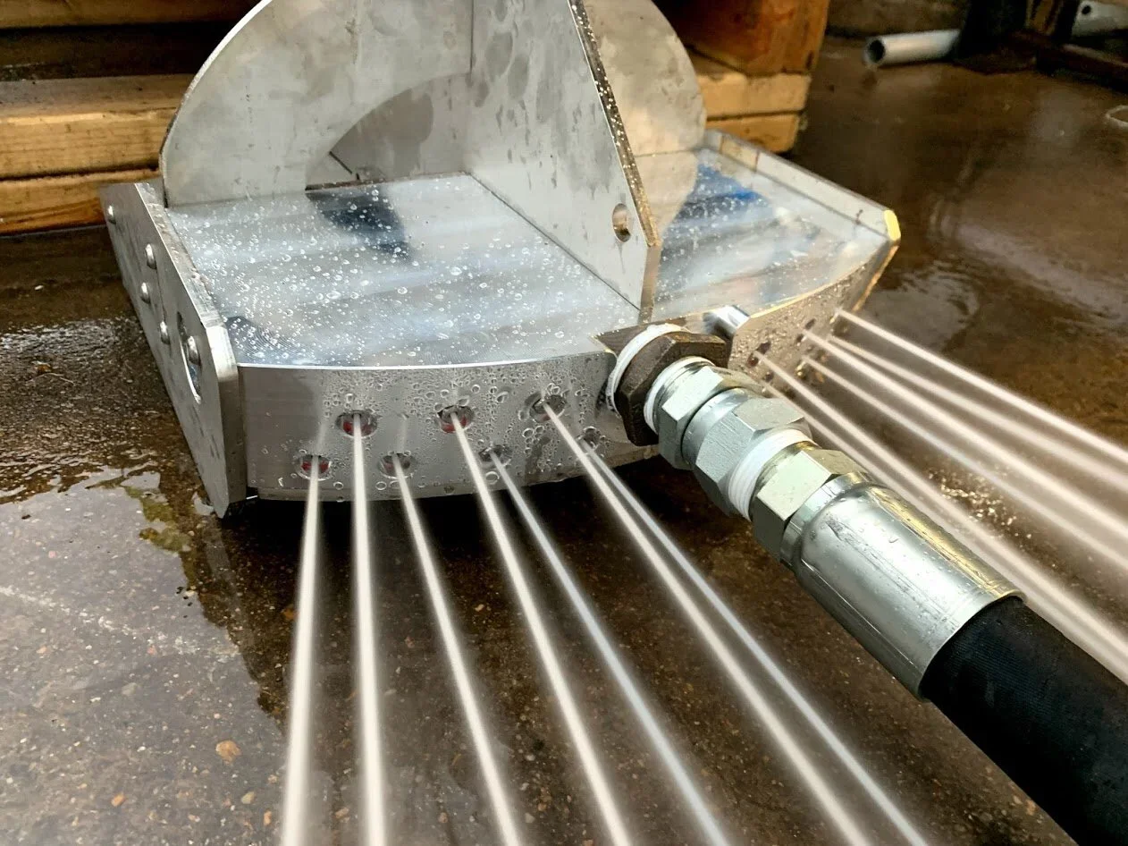 close up of a red dawg bulkhead nozzle spraying water. 