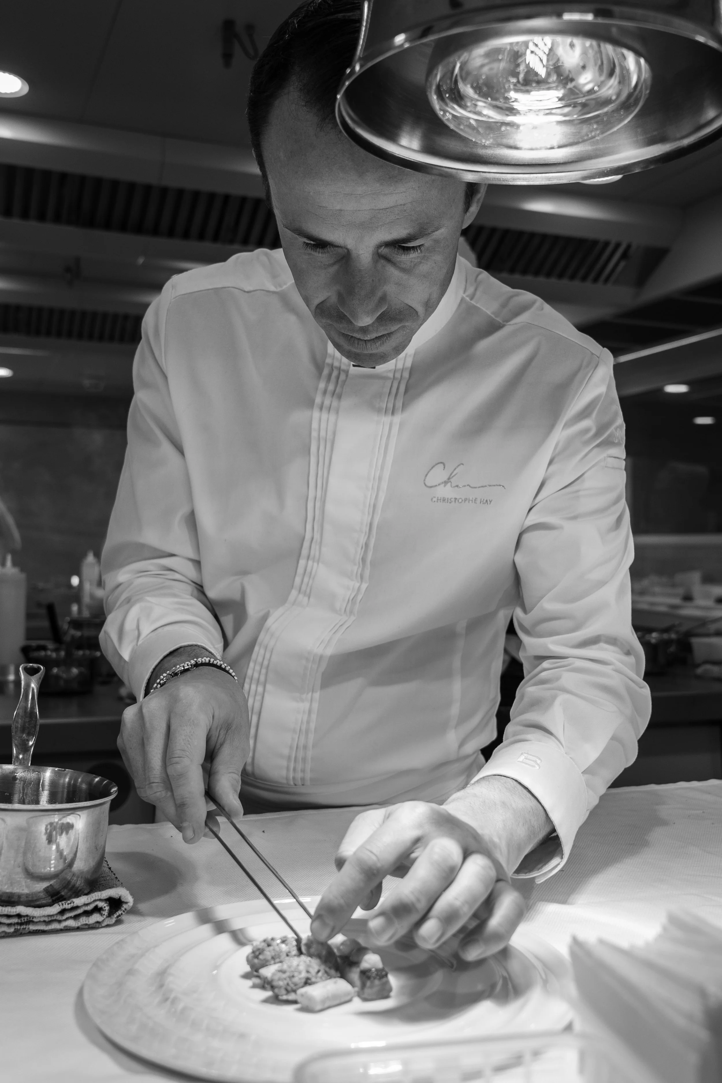 Chef en train de préparer des plats dans une cuisine professionnelle.