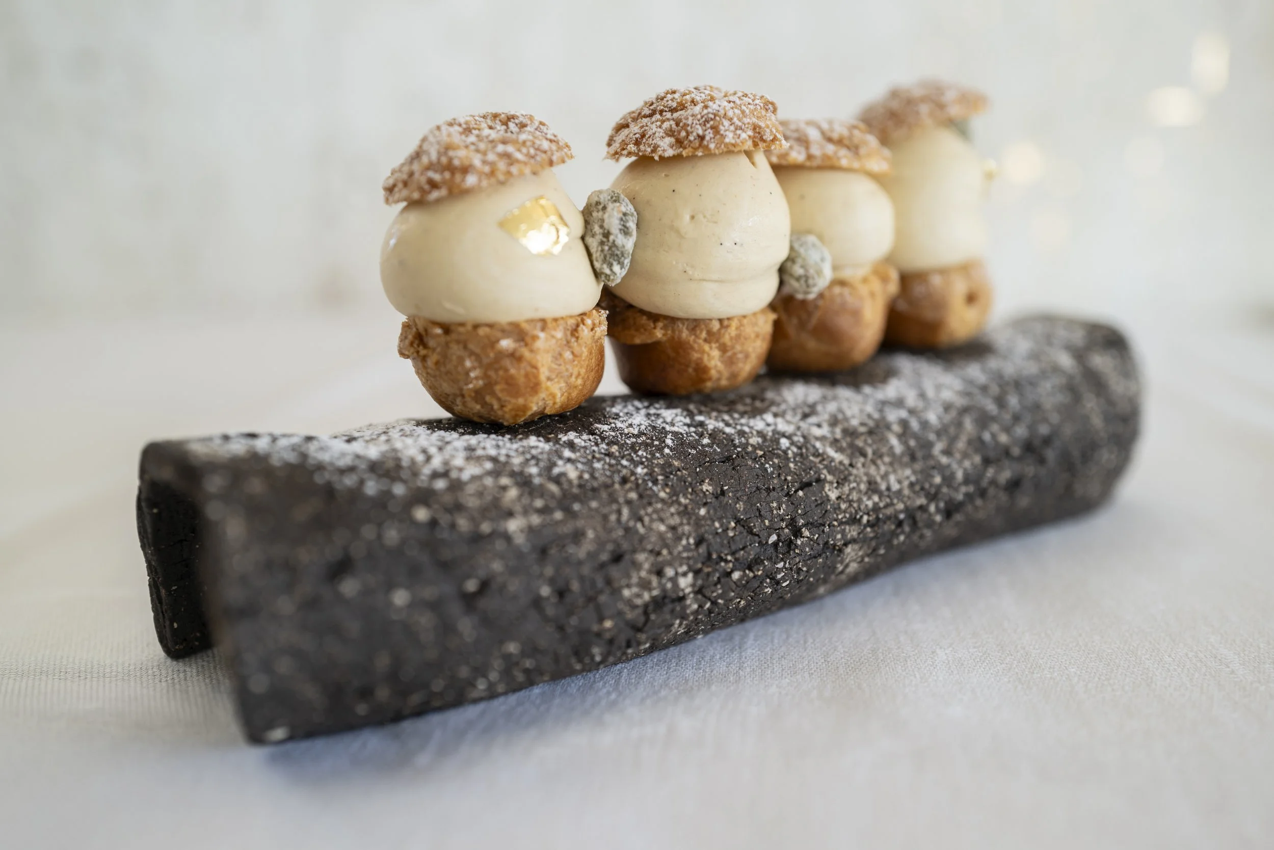 Gâteau en forme de personnage avec trois têtes, sur une plaque allongée.