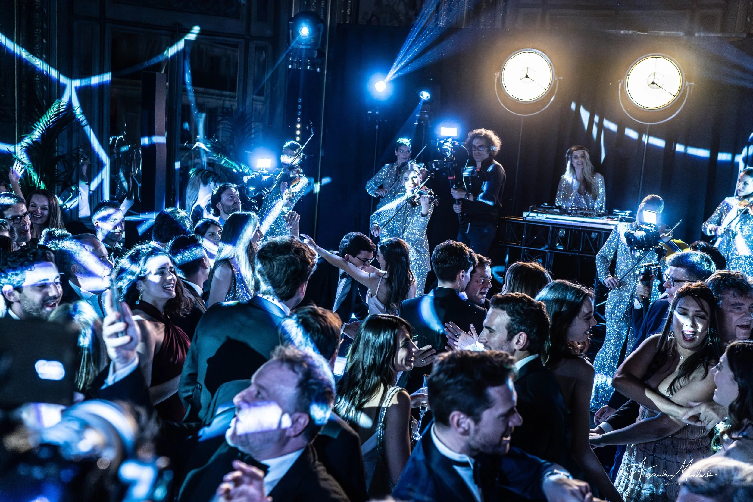 Une soirée dansante avec un groupe de musiciens en paillettes et une foule de personnes élégantes qui dansent.