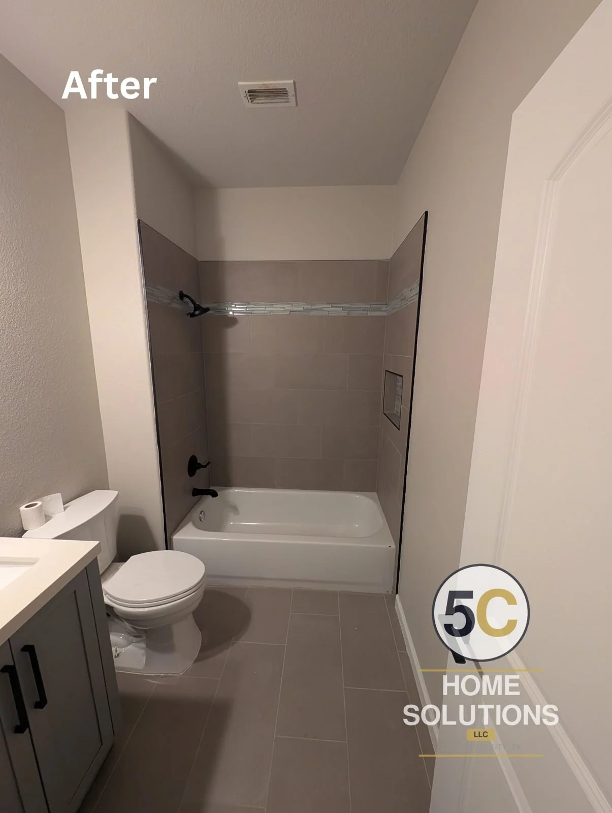 After: tub shower with large-format gray tile, glass mosaic accent band, recessed niche and matte black fixtures by 5C Home Solutions, Denton County TX