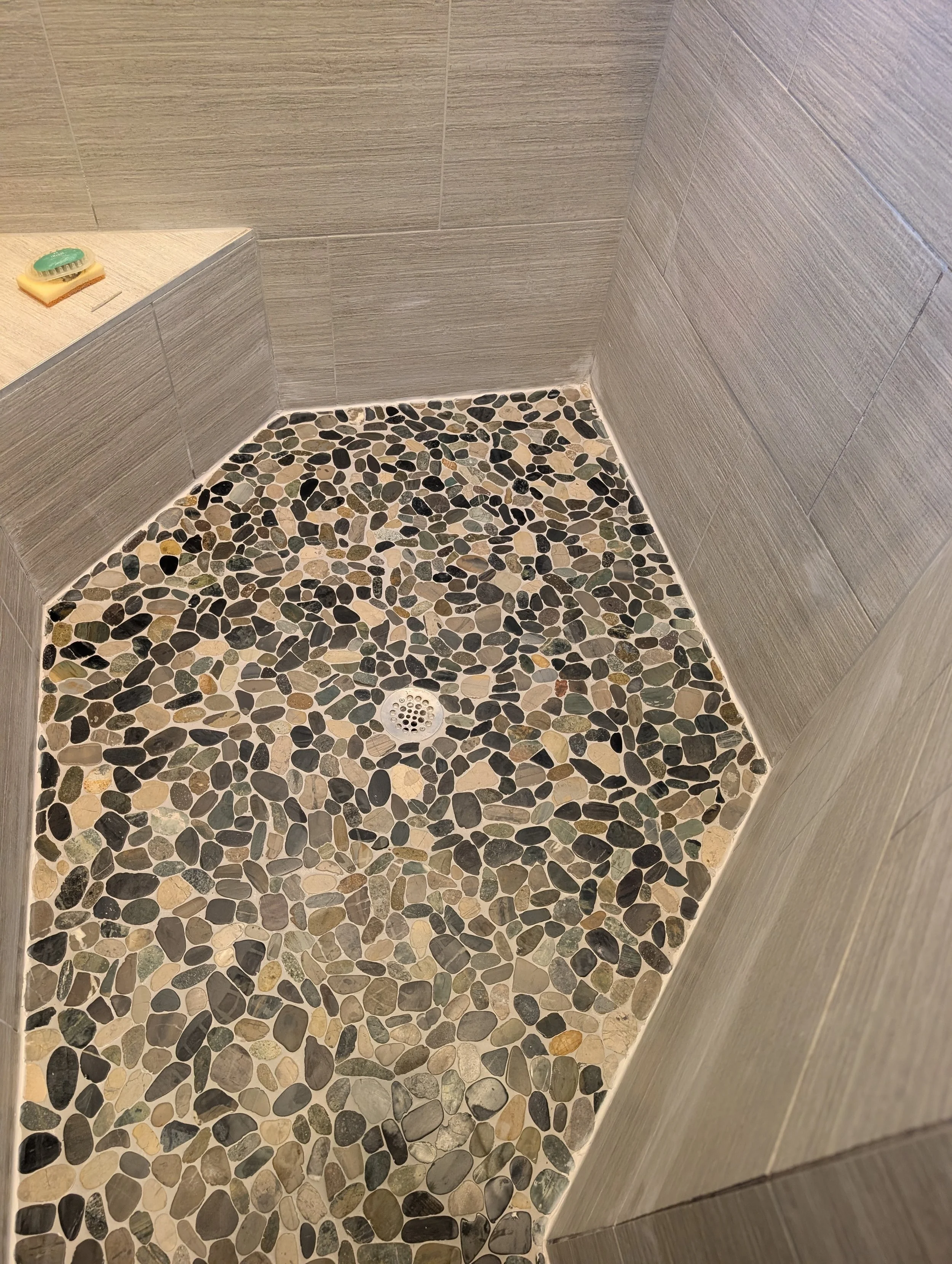 Custom pebble stone shower floor installation in Denton, TX. Natural river rock mosaic tile with clean caulking and professional finish — by 5C Home Solutions.