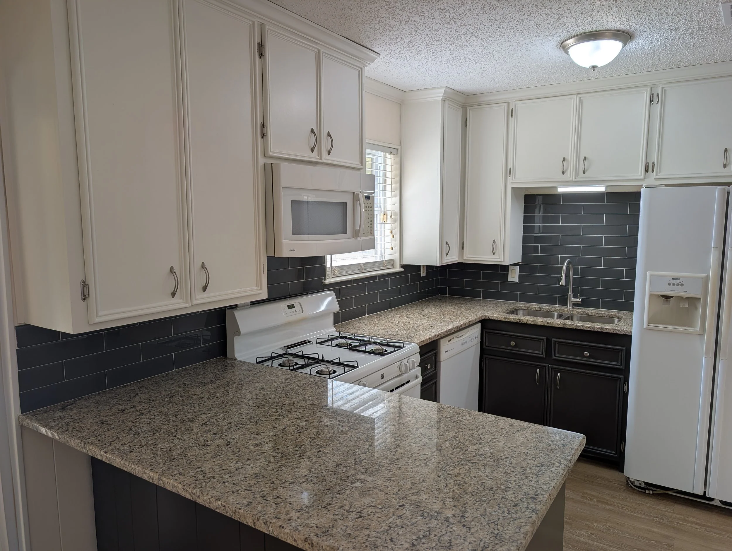 Two-tone cabinet painting and backsplash installation in Denton County, TX. Professional kitchen cabinet painting transforms outdated oak cabinets into a modern, high-contrast finish.
