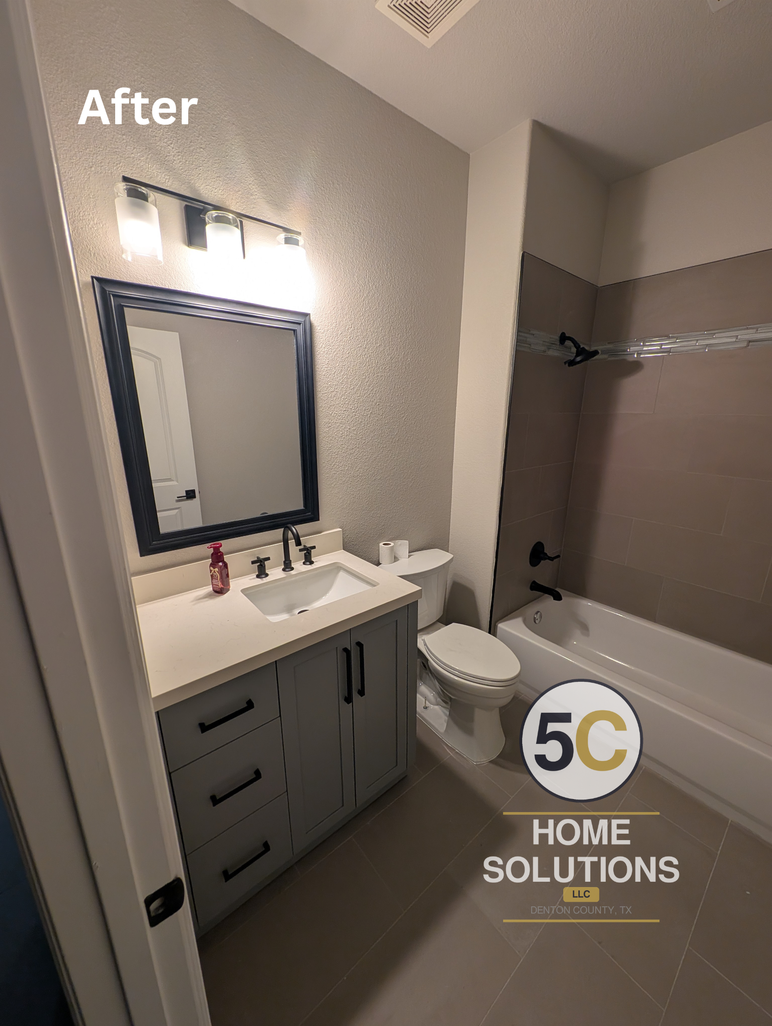 Full view of the finished guest bathroom, including a gray shaker-style vanity with quartz countertop, framed mirror, updated lighting, and matching matte black hardware throughout — completed as part of a guest bathroom renovation in Lake Dallas, TX