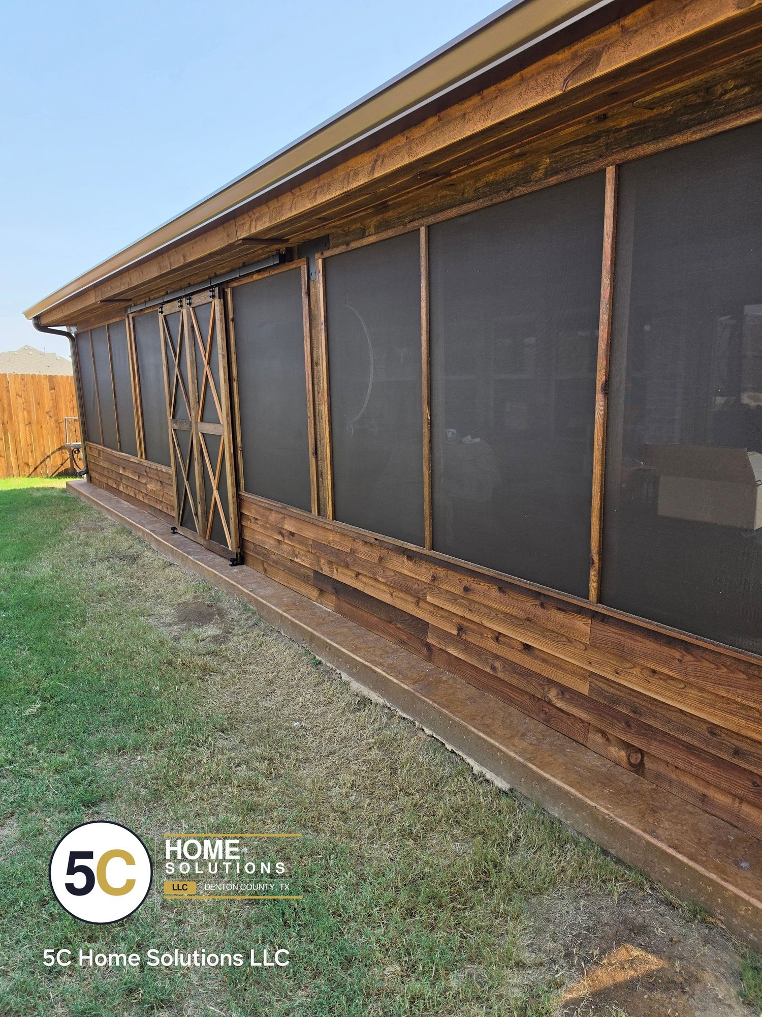 Long cedar screened porch with sliding barn doors and cedar knee wall