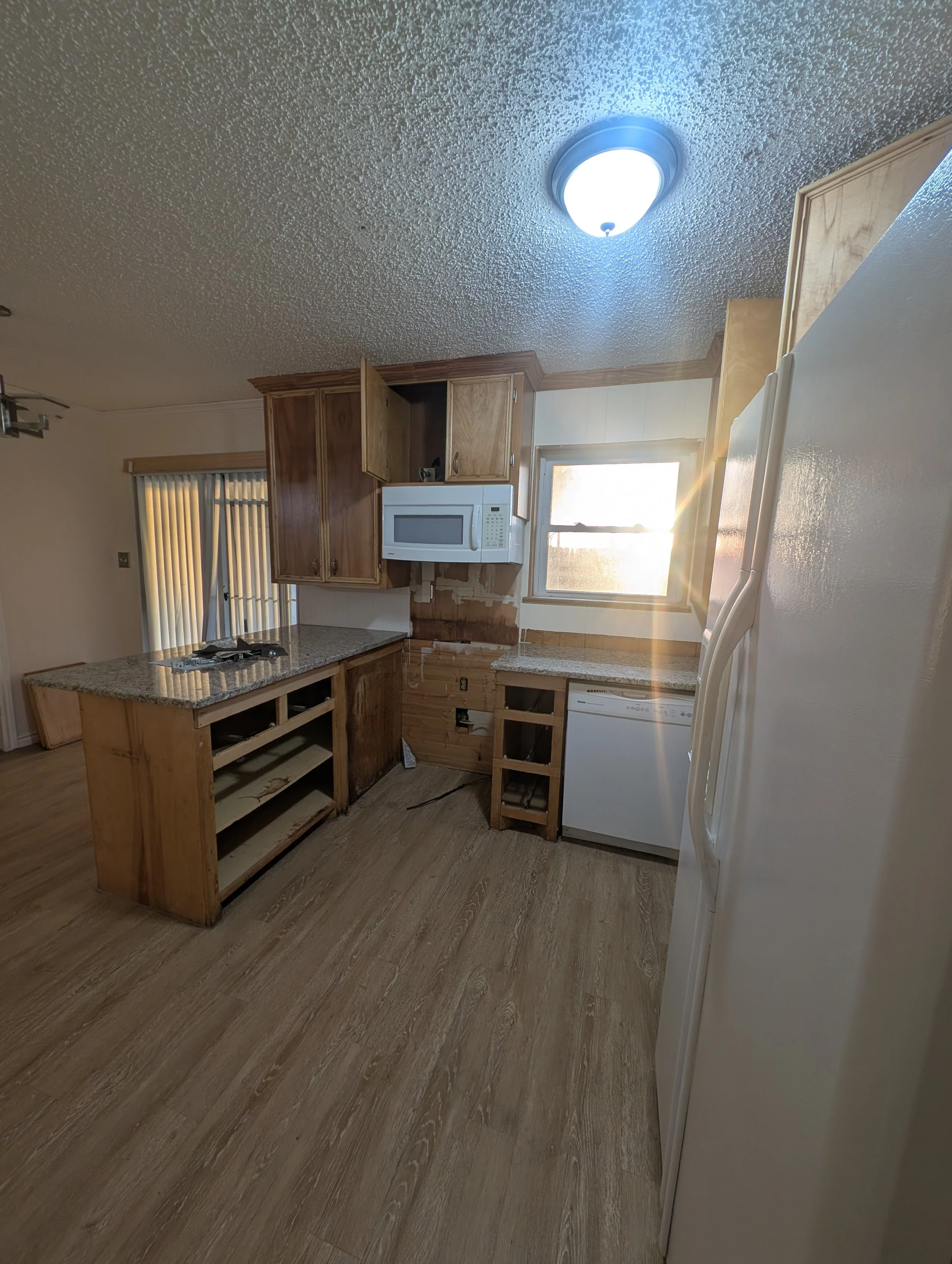 Kitchen cabinets stripped and prepped for painting in Denton, TX. 5C Home Solutions handles full cabinet painting and kitchen refresh services across Denton County.