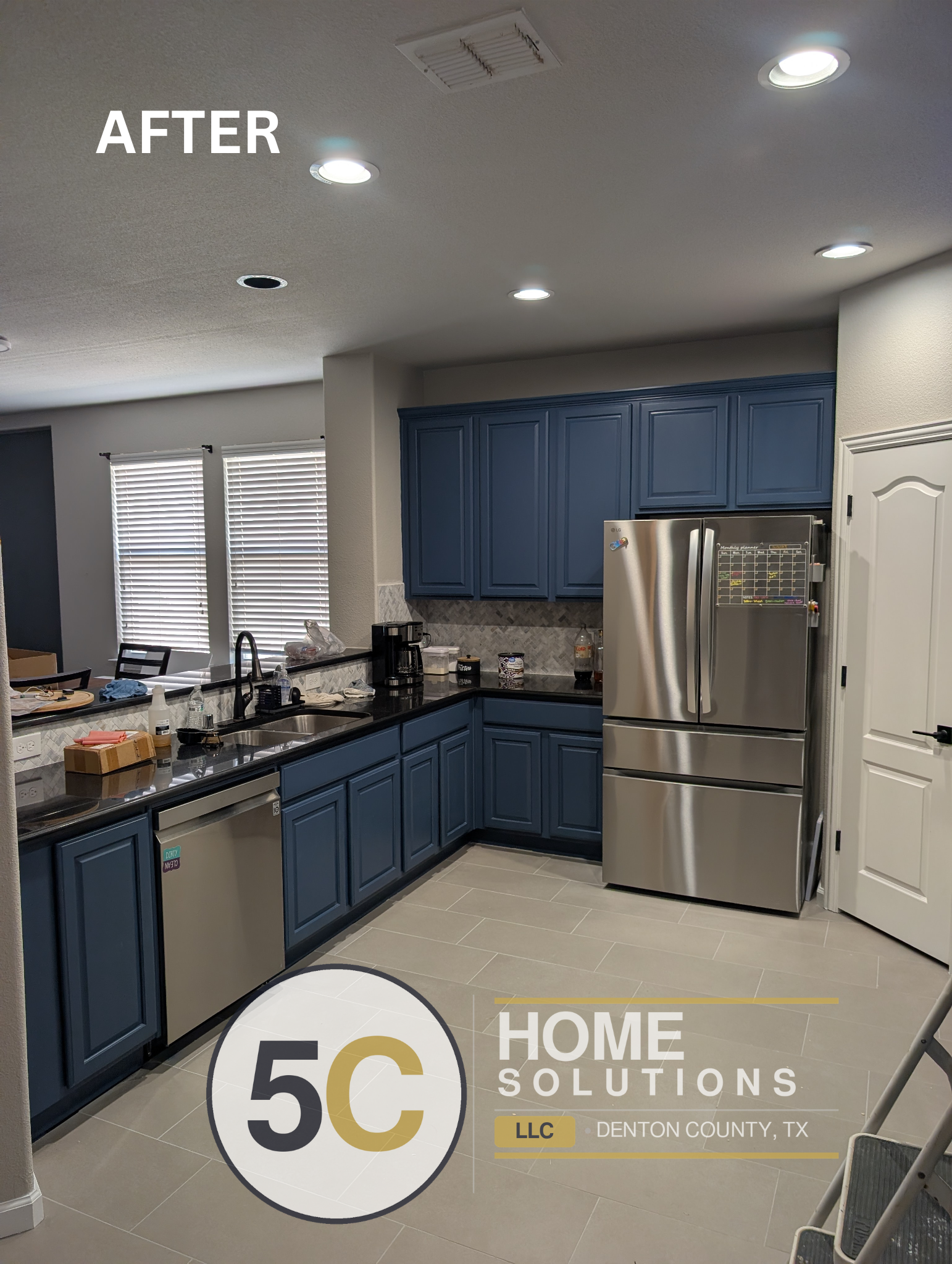 A wider view of the completed Lake Dallas kitchen showing the full run of slate blue cabinetry, stainless steel appliances, and matching herringbone backsplash tile. The finished tile flooring ties the whole space together for a clean, updated look.