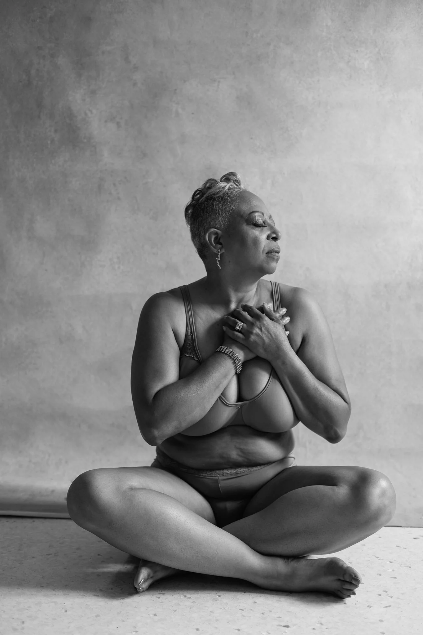 " Natural light boudoir session woman sitting crossed legged"