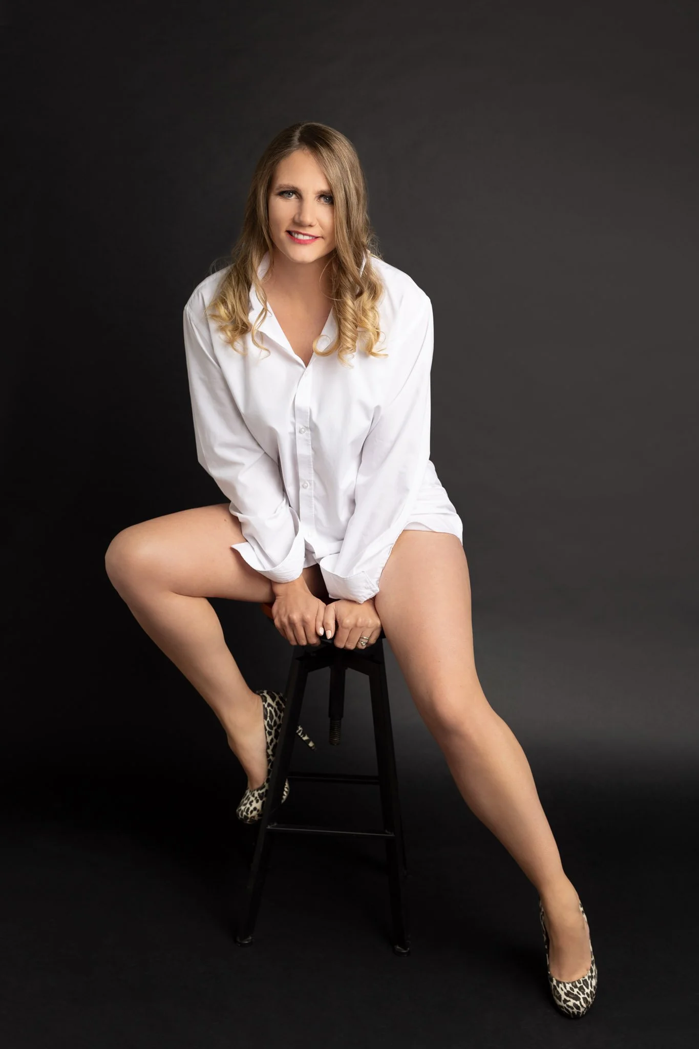 woman posing on stool wearing white shirt & legs on show  Shropshire boudoir studio