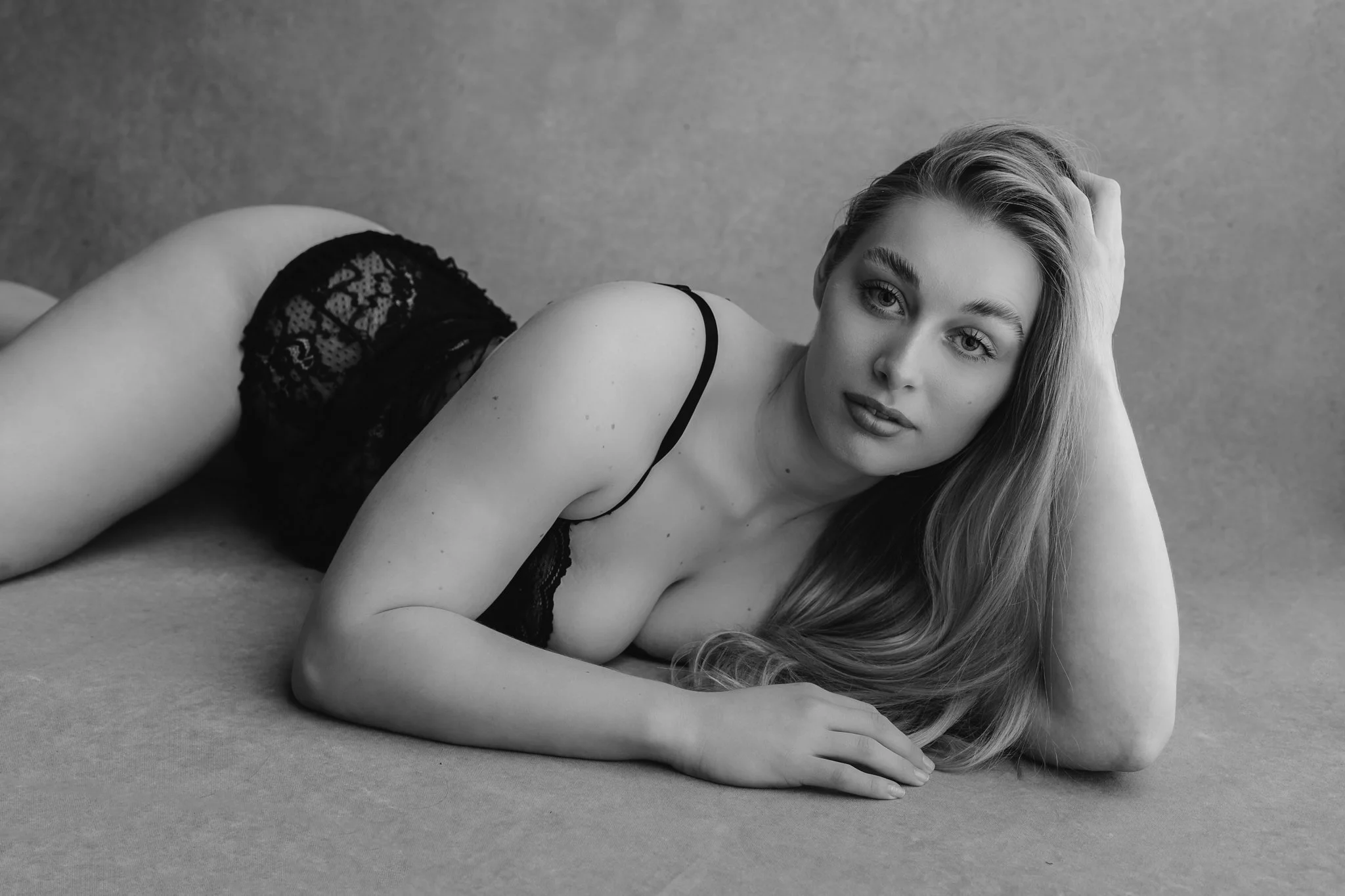 "Empowering studio portrait of woman lying on floor in soft light"