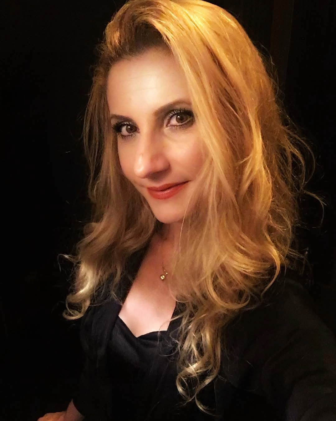 Headshot of Aura Mihai on black background.