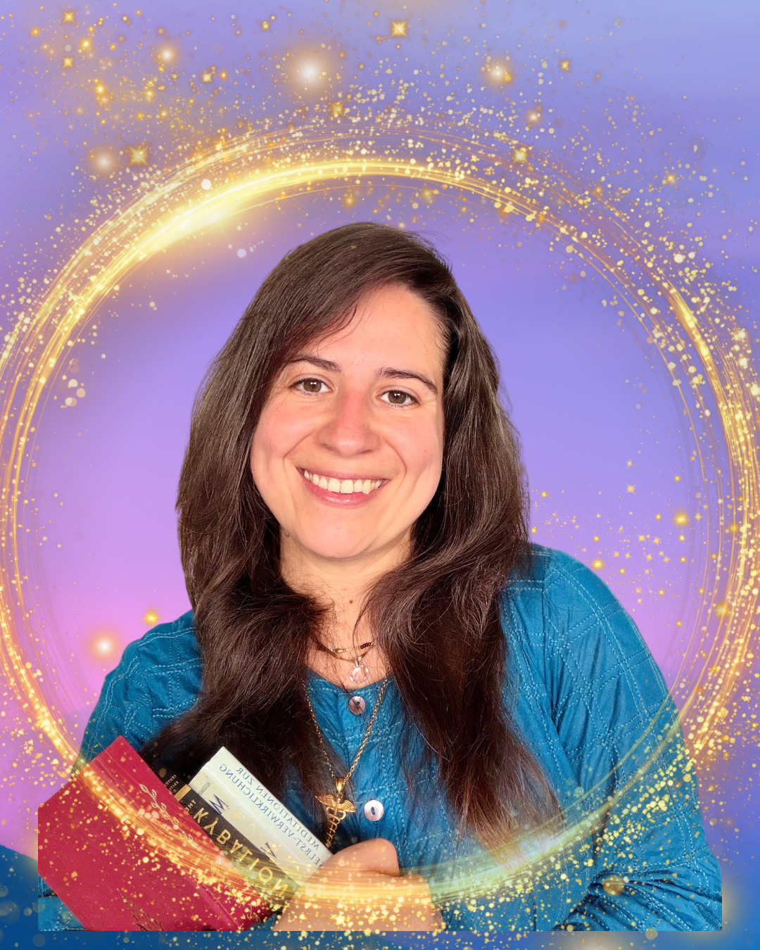 Woman with long brown hair smiling, holding a yellow booklet and a few cards, standing in front of a purple background with golden sparkling circular effects.