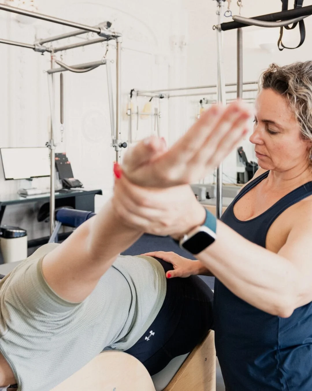 A physical therapist assisting a patient with leg exercises in a rehab clinic.