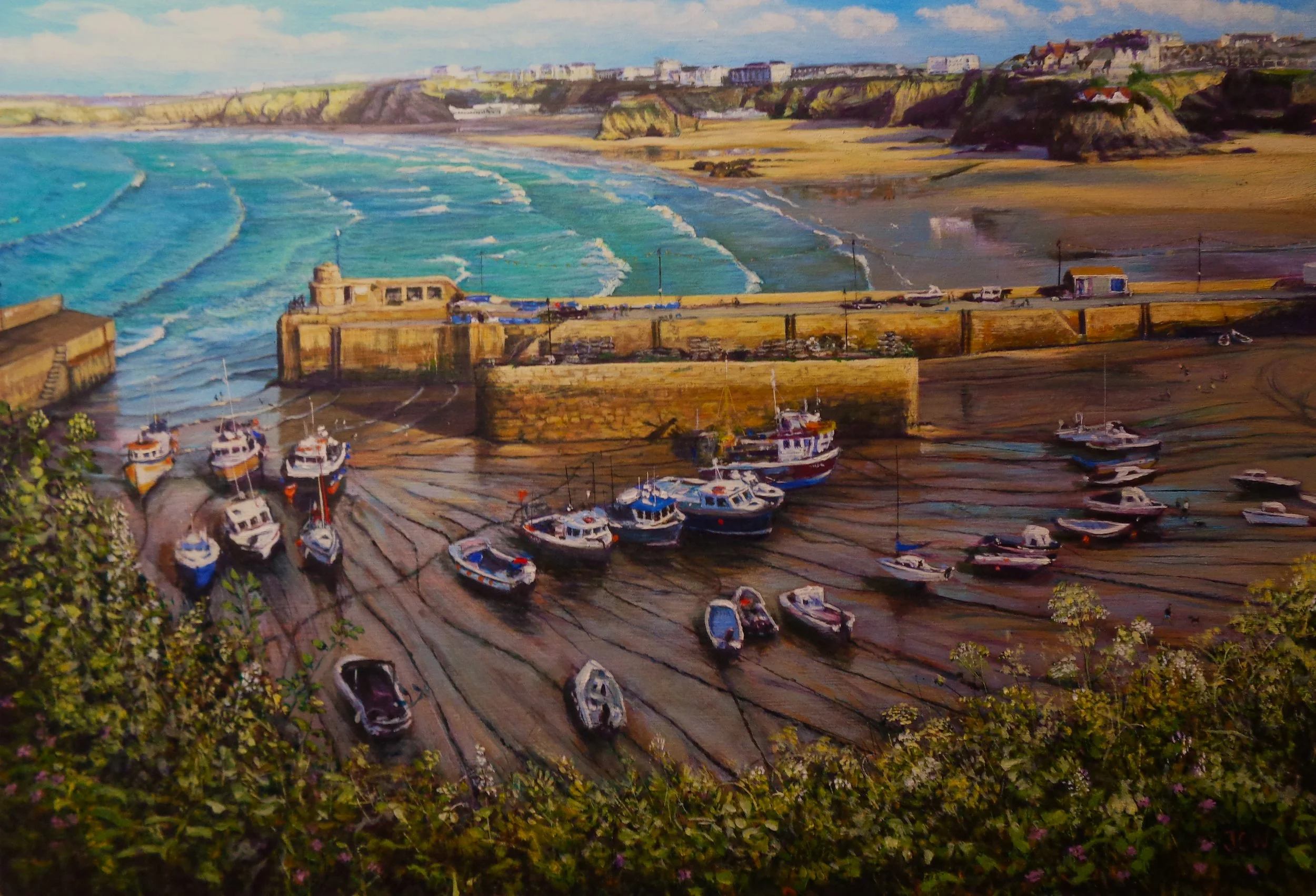 Painting of a seaside harbor with boats in the mud, a stone wall, and a coastal town with cliffs in the background.