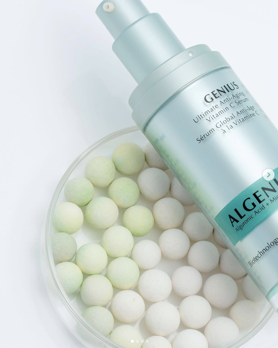 Agenist Genius Ultimate Vitamin C Serum shot on top of beads that fade from darker to lighter to illustrate dark spots fading.