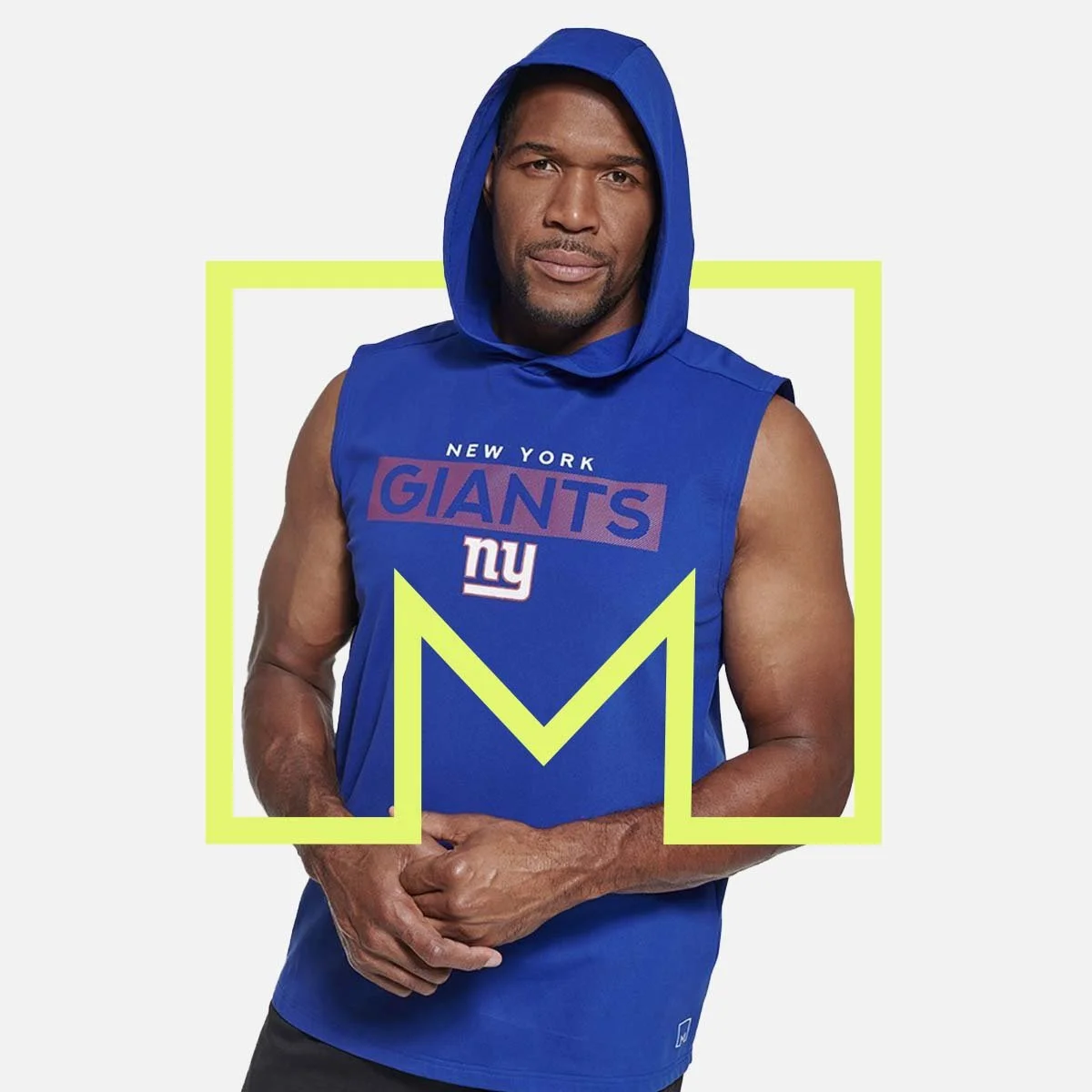 Michael Strahan wearing a sleeveless blue hoodie with the New York Giants logo, standing against a white background with a yellow frame around him.