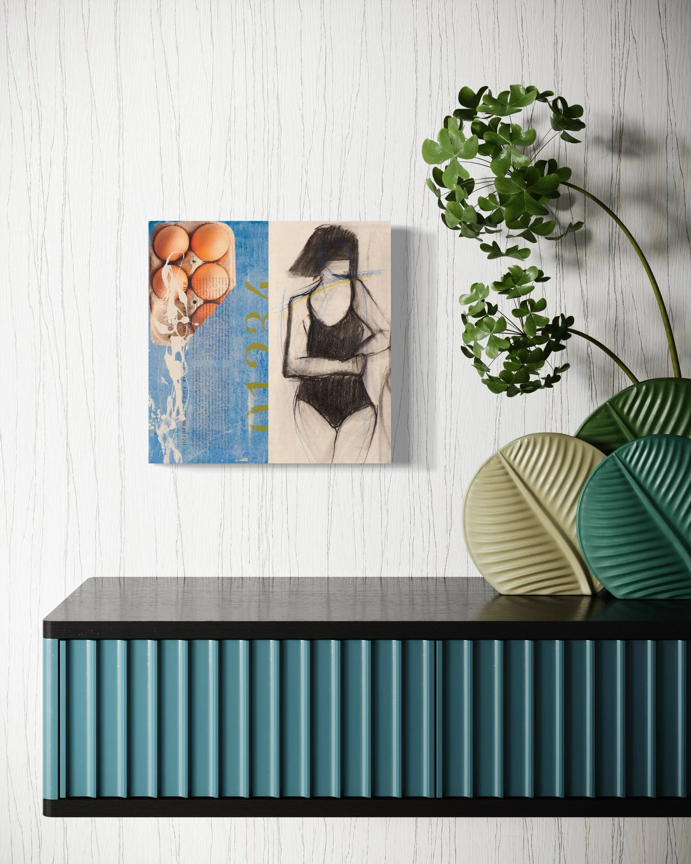 Decorative wall art featuring eggs and a stylized sketch of a woman in black swimsuit, positioned above a black and teal striped cabinet with green and cream leaf-shaped vases and a leafy plant to the right.