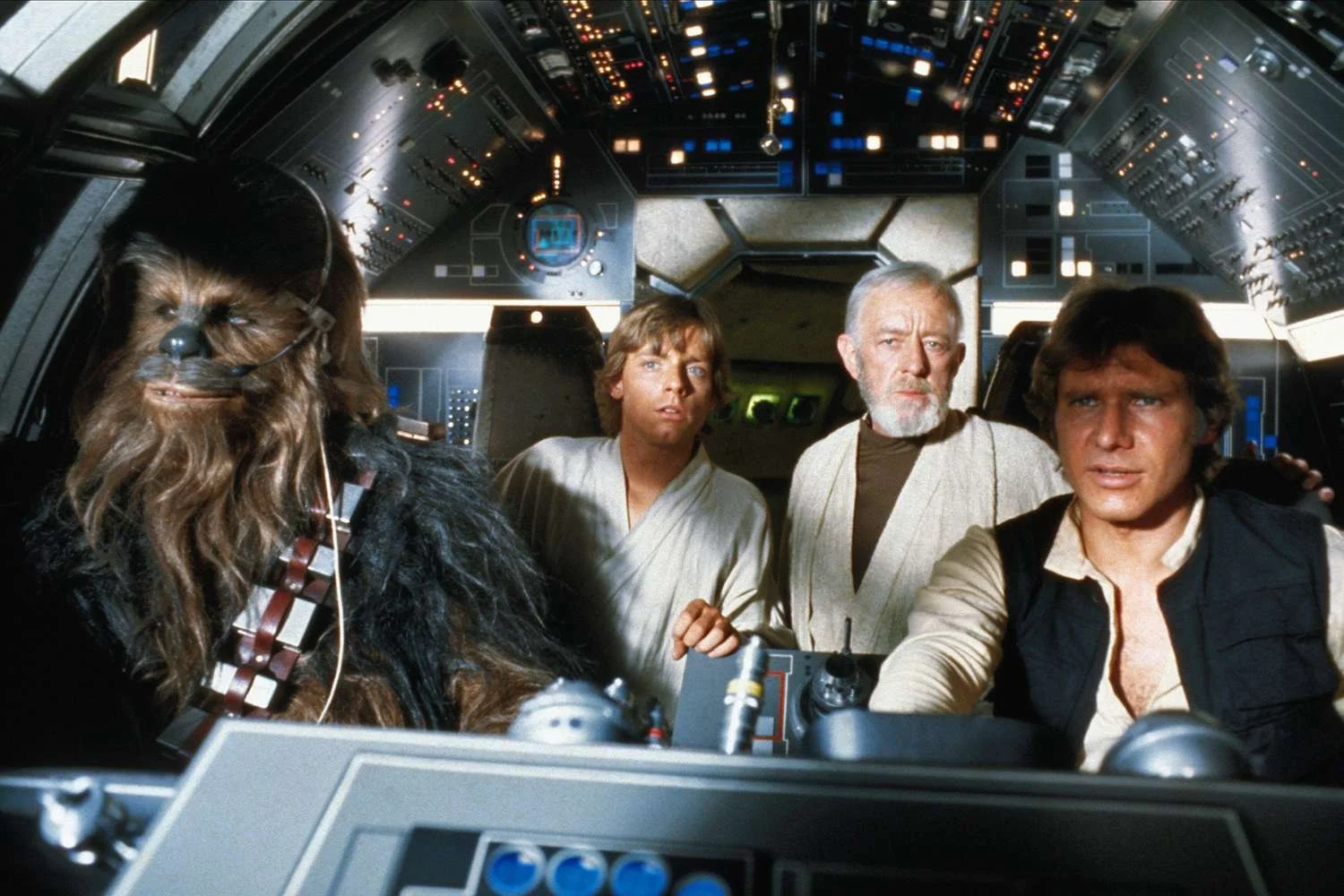 Han, Chewie, Obi Wan Kenobi, and Luke Skywalker in the cockpit of the Millennium Falcon in "Star Wars"