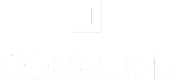 Close-up of the word 'COMMUNE' in large, white, embossed letters on a surface.
