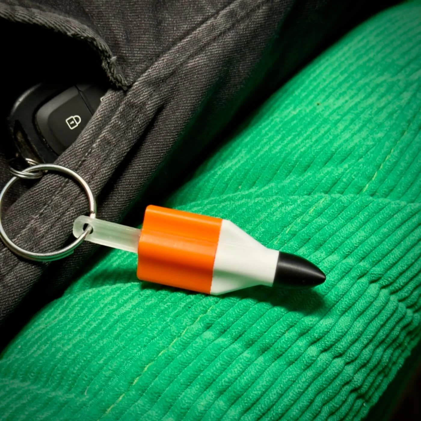 Rocket Keychain on green textured fabric