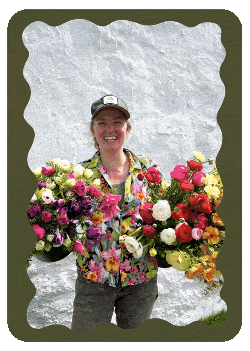 Woman smiling, holding colorful flower bouquets, standing in front of a white textured wall.