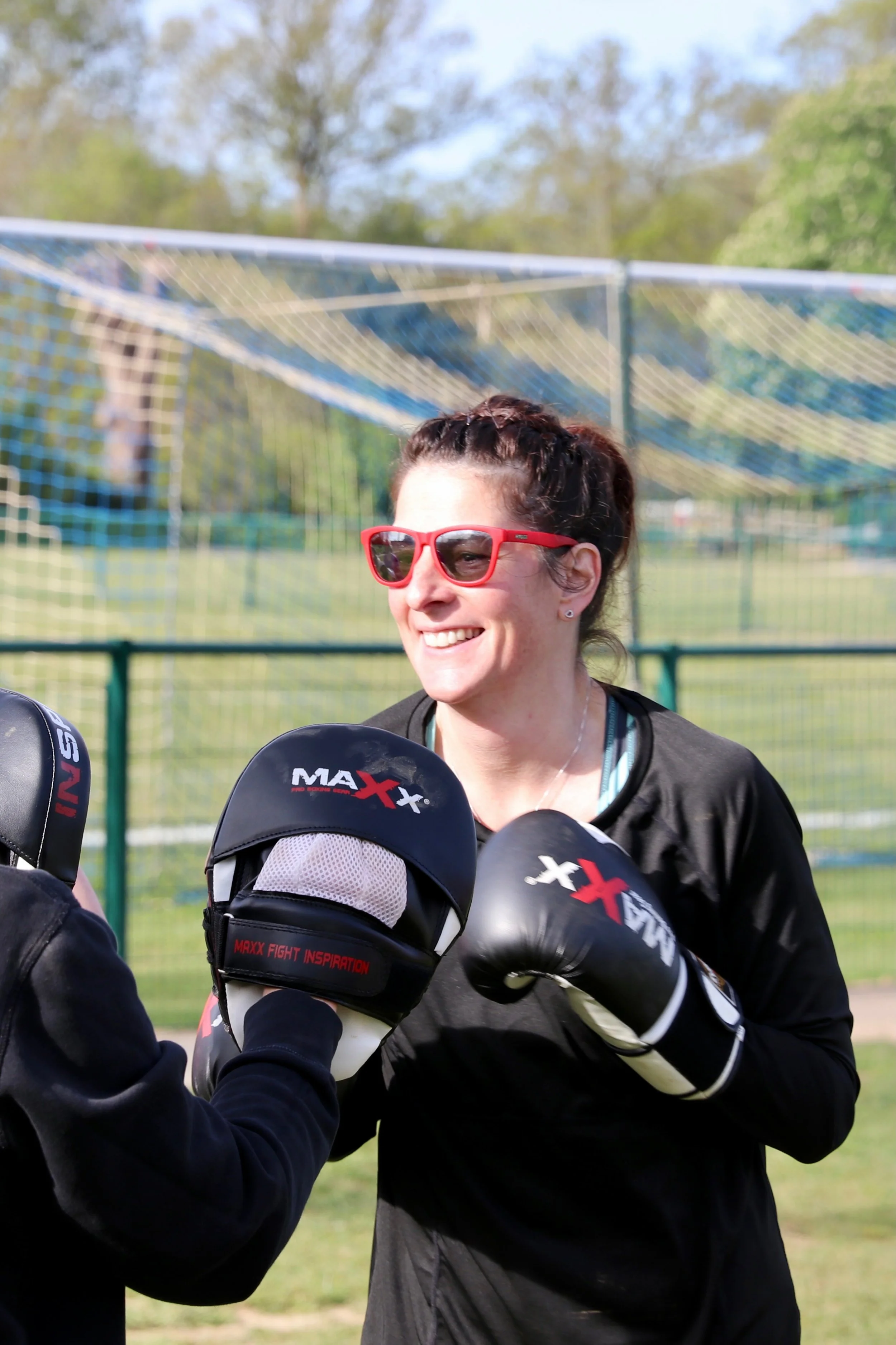 Happy female attendee at a boxing workout session.