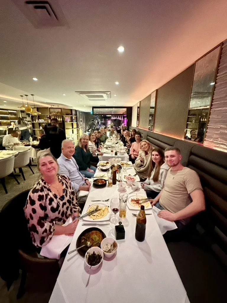 Outdoor fitness in Cranleigh. Group of people dining together at a restaurant table, enjoying a meal and socializing.