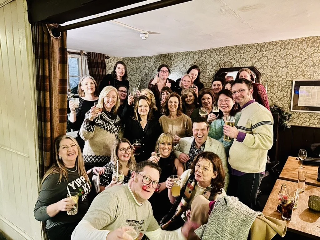 Outdoor fitness in Cranleigh. Group of people celebrating with drinks in a cozy, decorated living room.
