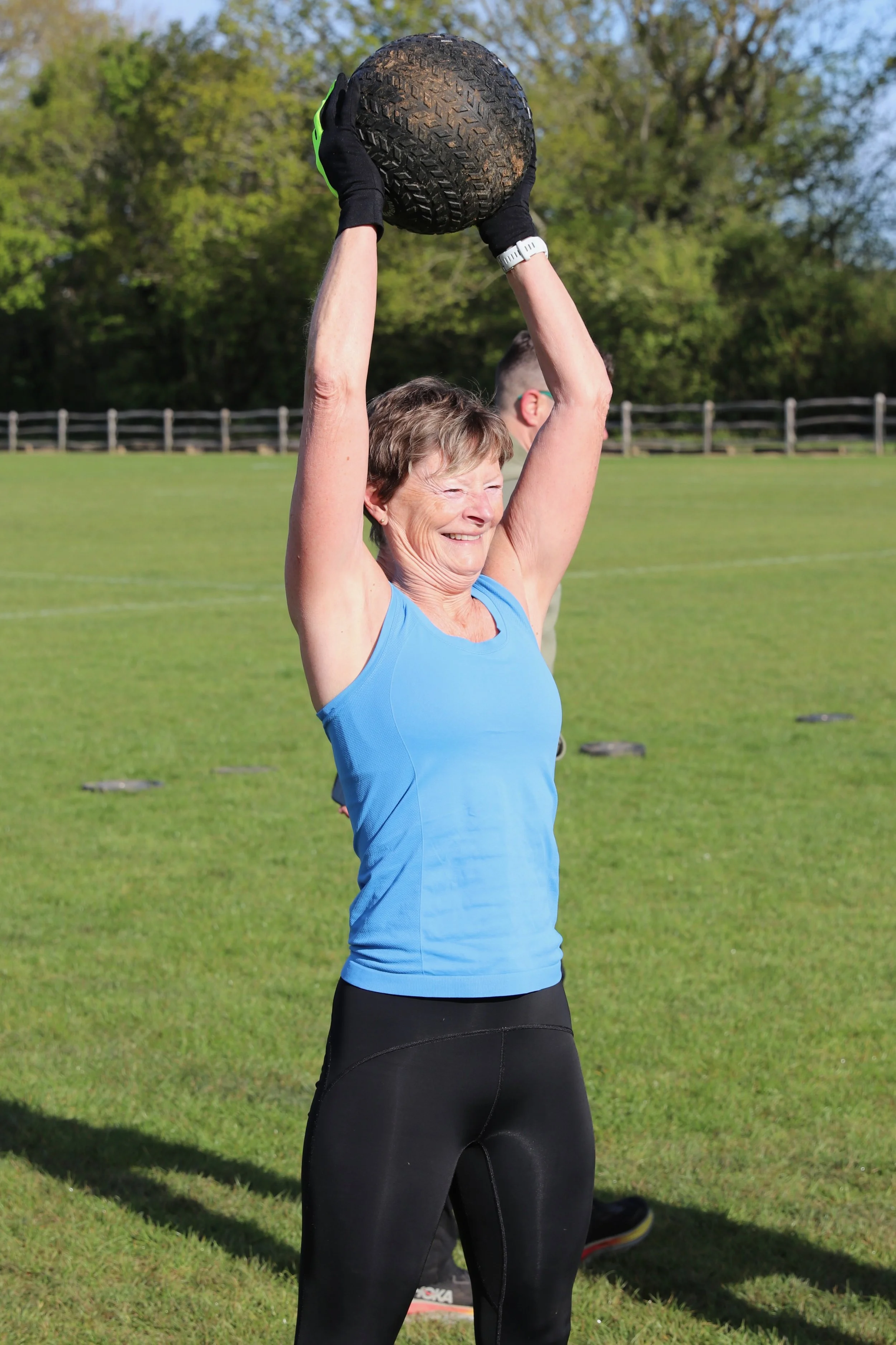 Women lifting a heavy exercise ball.