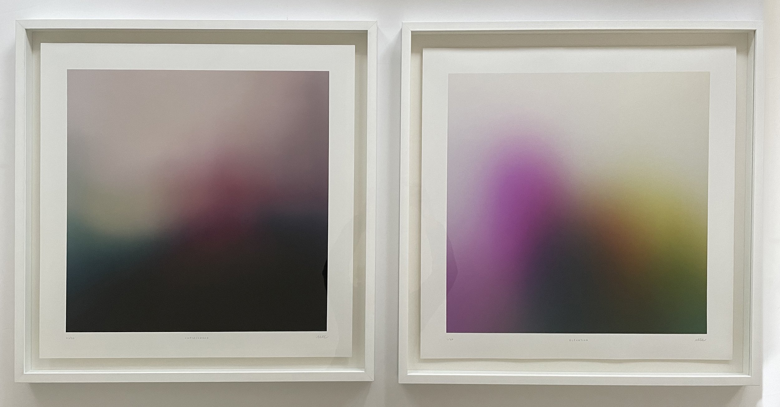 Two framed abstract gradient art prints are displayed on a white wall. The left artwork features muted tones blending into darker shades, while the right artwork displays softer pastel colors blending into a light background.