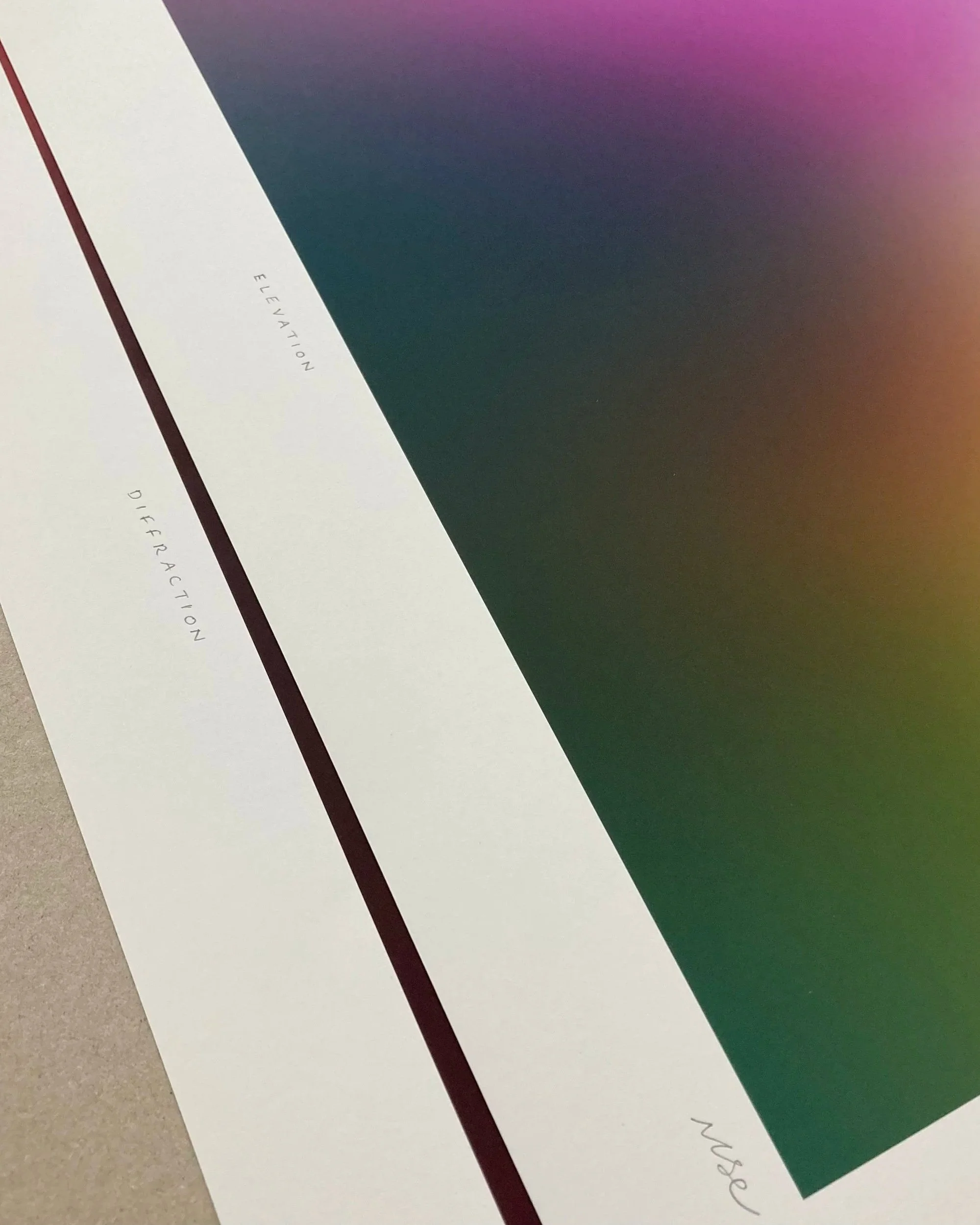 Close-up photo of a coupke of limited edition giclée prints. The background features a gradient of purple, pink, and orange colors.