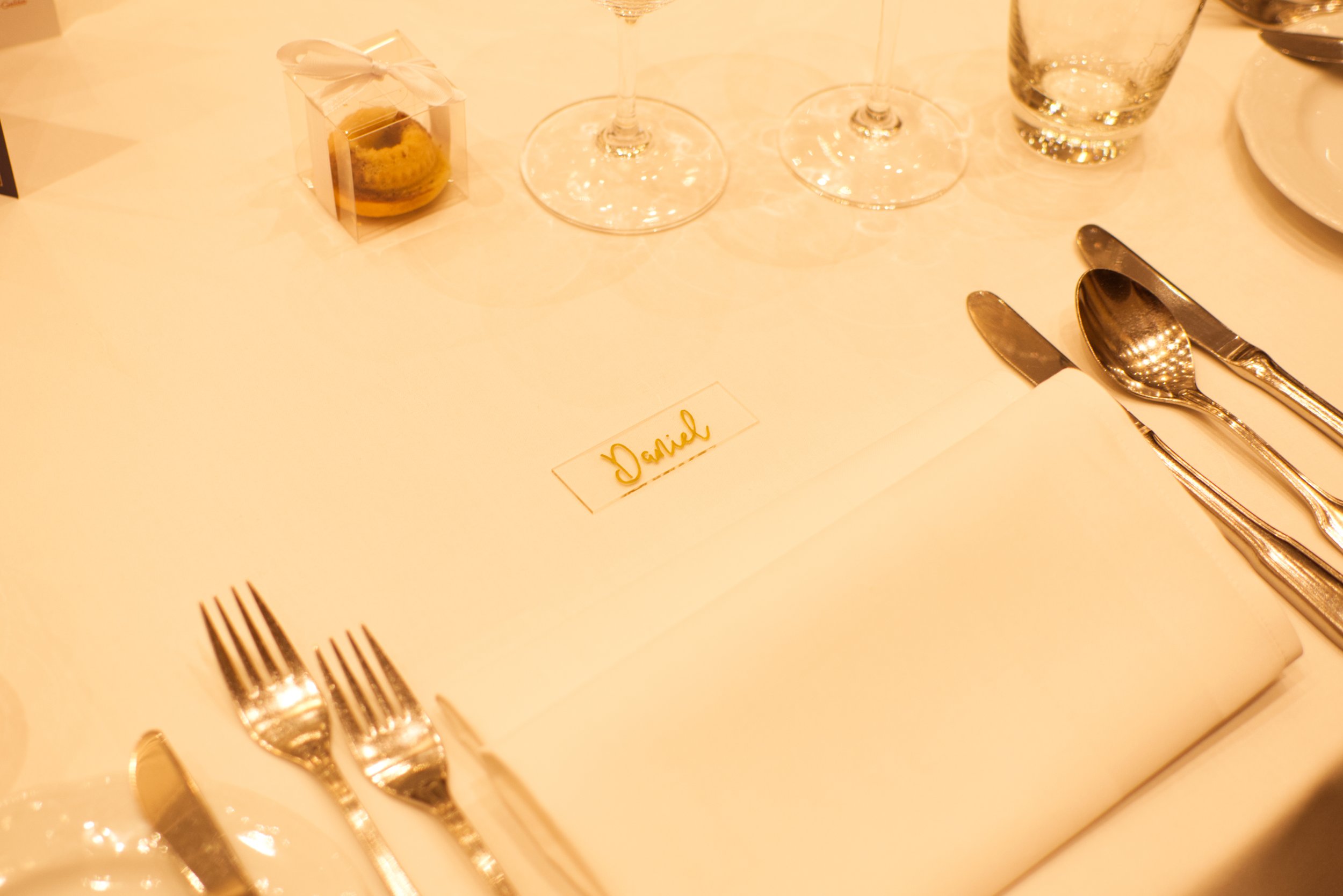 Ein gedeckter Esstisch mit Besteck, Gläsern und einem Namenetikett mit dem Namen Daniel.