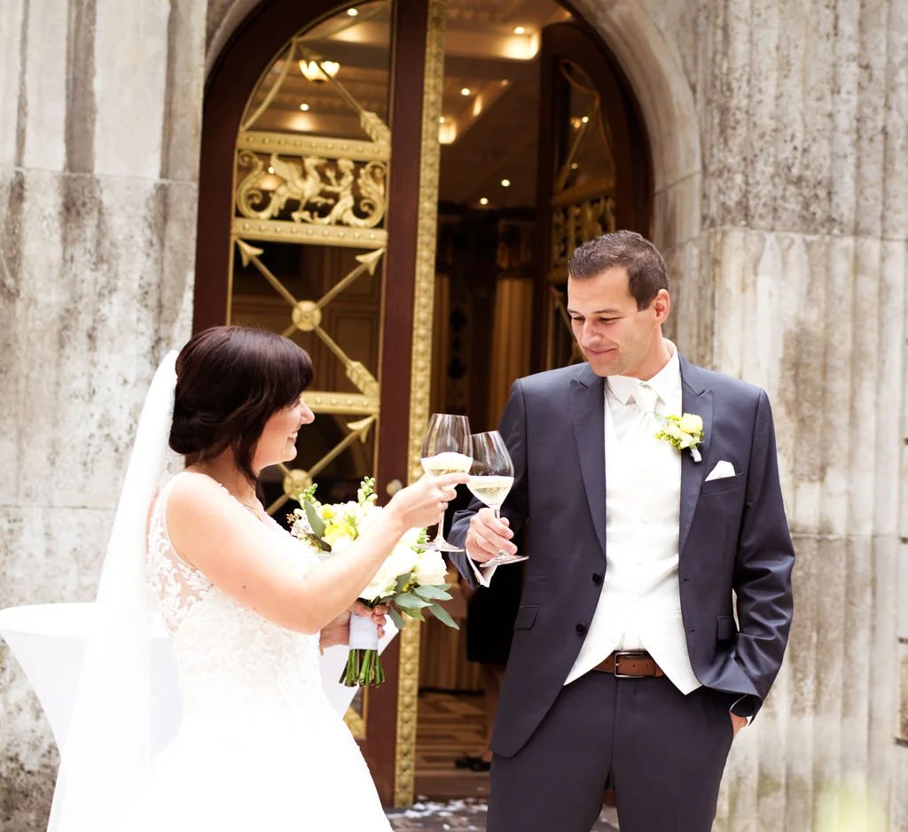 Laurie’s customers, Mariana and Carmen holding hands on a green lawn on their wedding day.