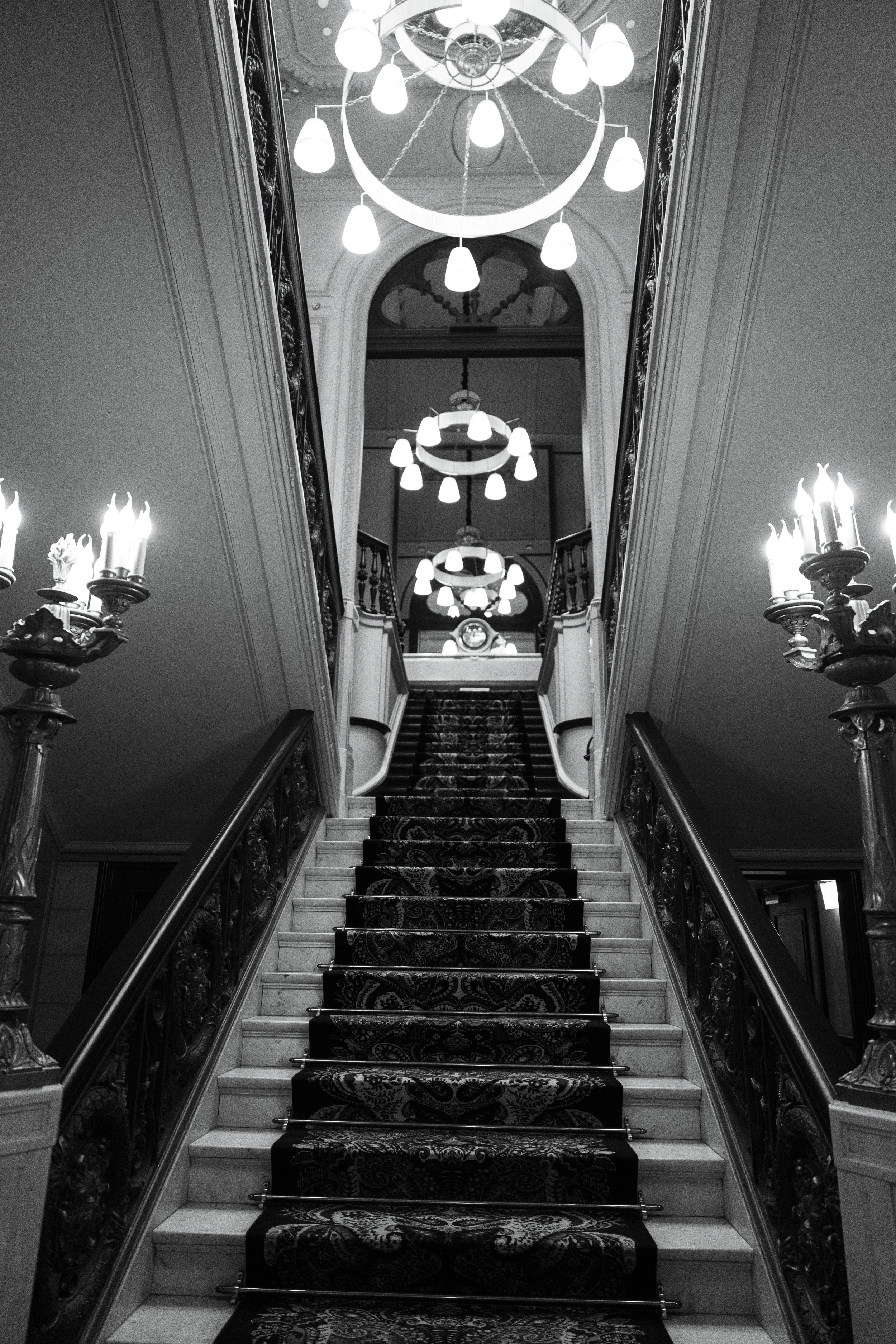 Wide view of the first ICONIC Studio event inside Hotel Des Indes, with Pilates mats arranged beneath crystal chandeliers.