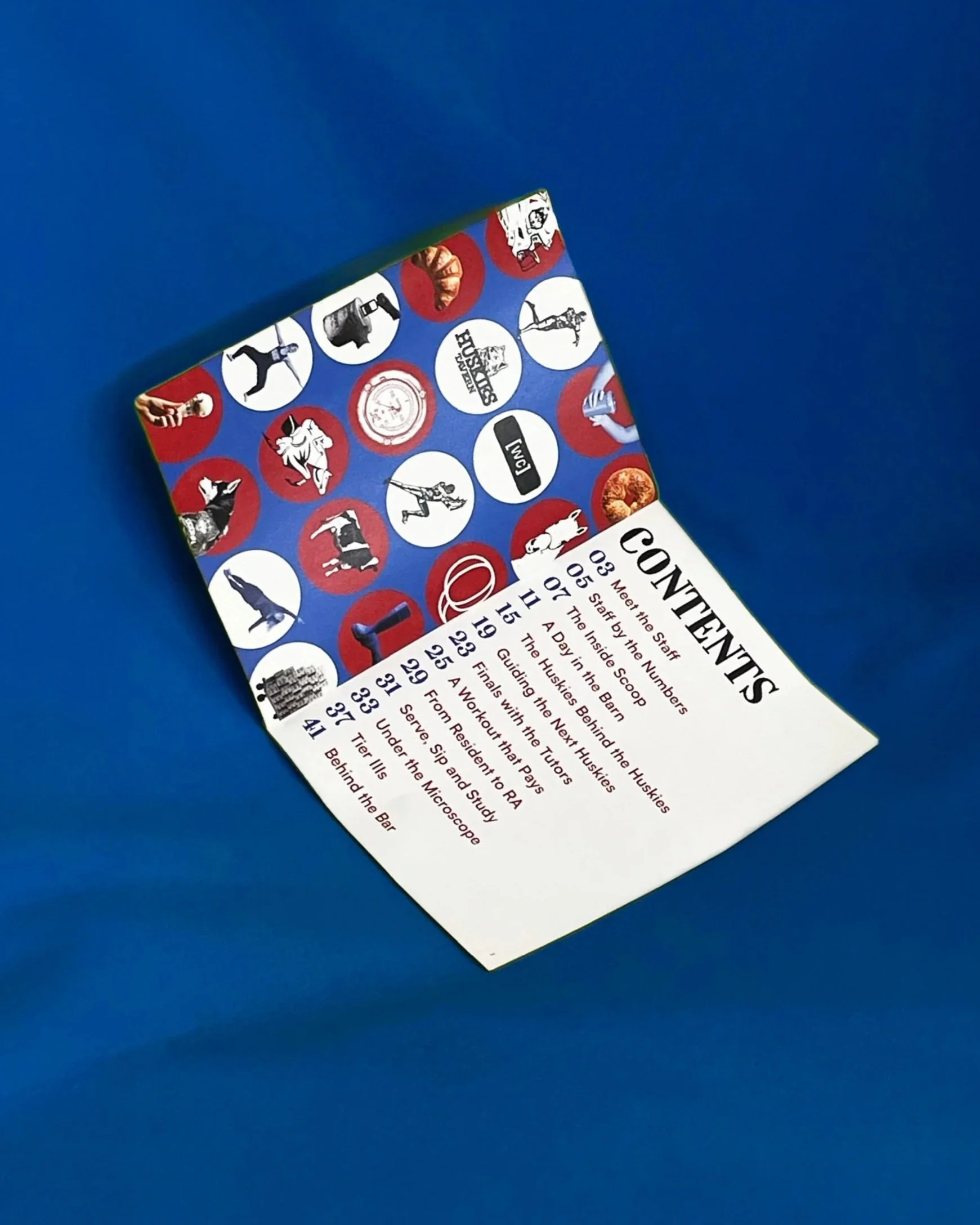 A printed itinerary or schedule for an event called 'Conference,' with dates and times, surrounded by icons representing various activities or topics such as a handshake, a dog, a squad, a computer, a skeleton, a dog, a microphone, and food items, set against a red, white, and blue background with a blue surface underneath.