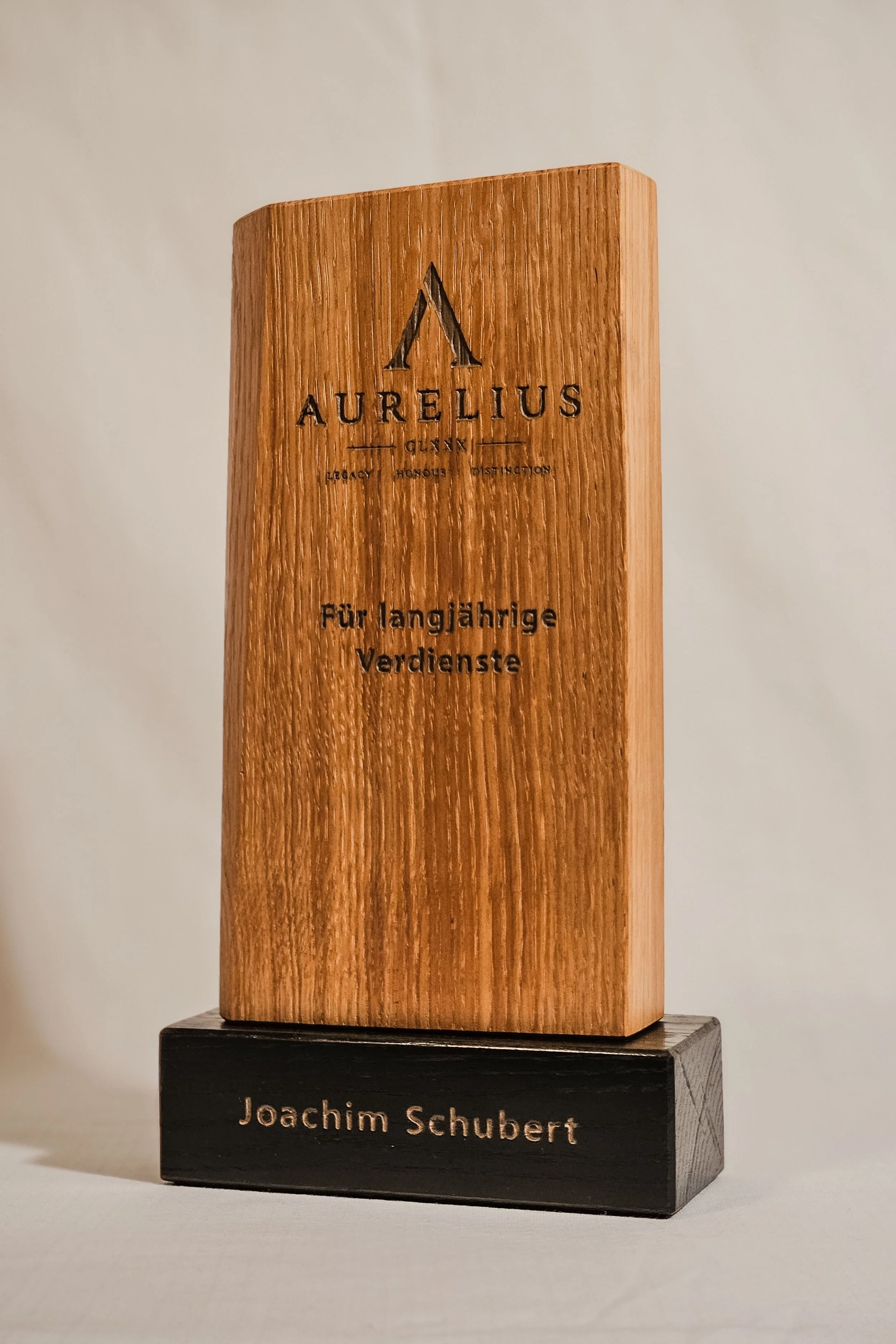 Ein Holzpreis für Joachim Schubert auf einem schwarzen Sockel.