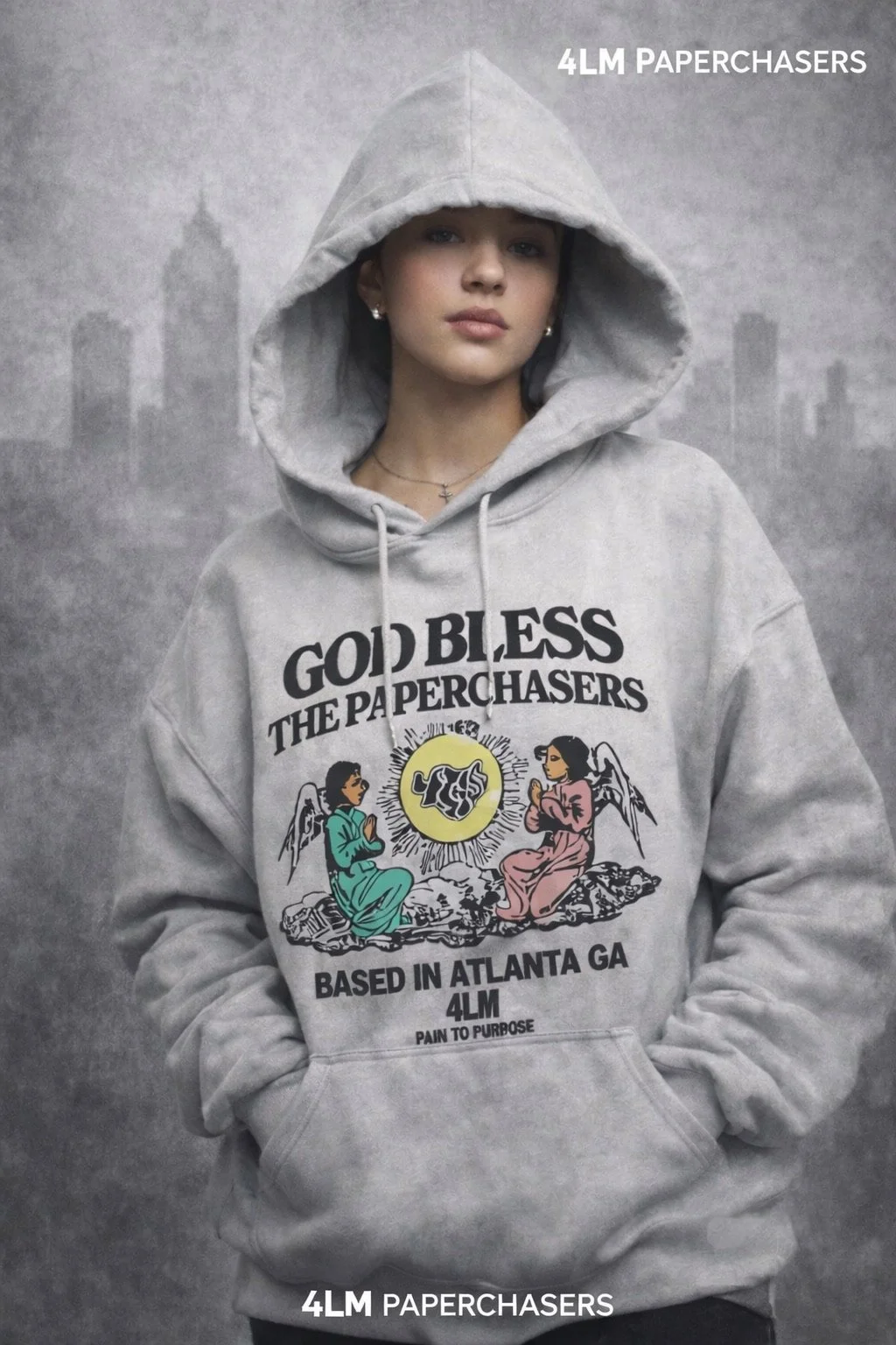 A young woman wearing a gray hoodie with a graphic that says 'God Bless the Paperchasers, based in Atlanta GA, 4LM, Pain to Purpose,' standing against a gray cityscape background.