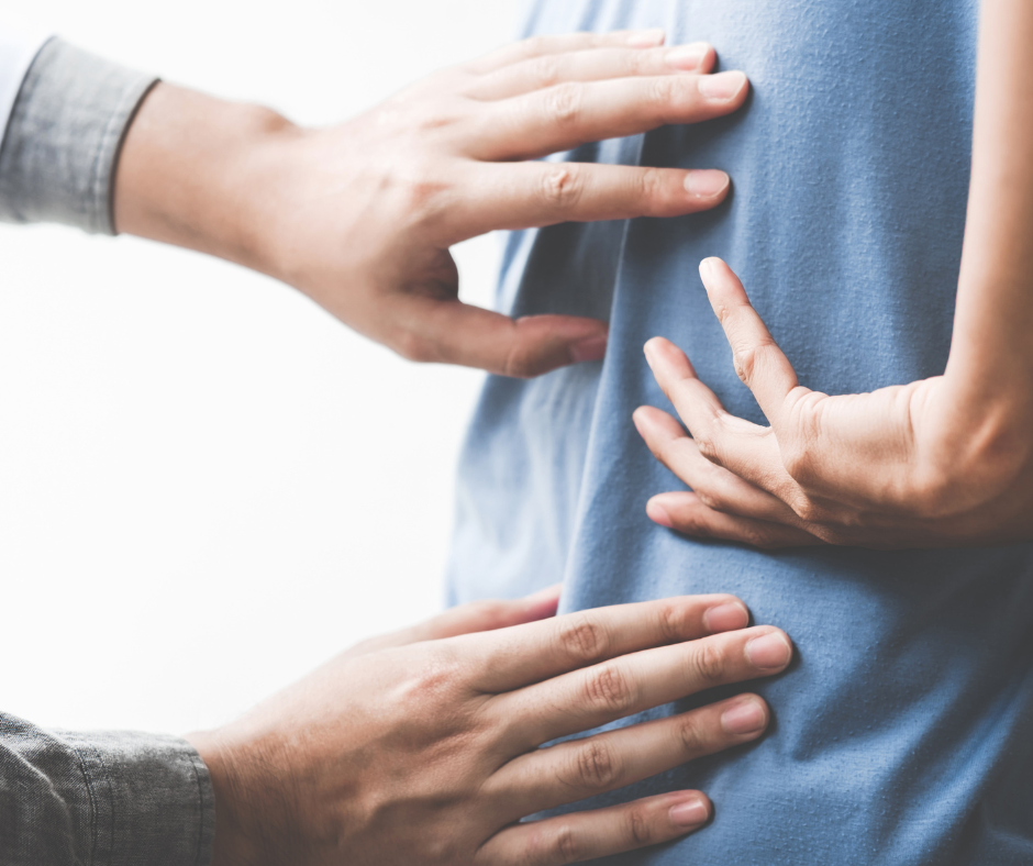 Multiple hands touching a pregnant belly in a supportive manner.