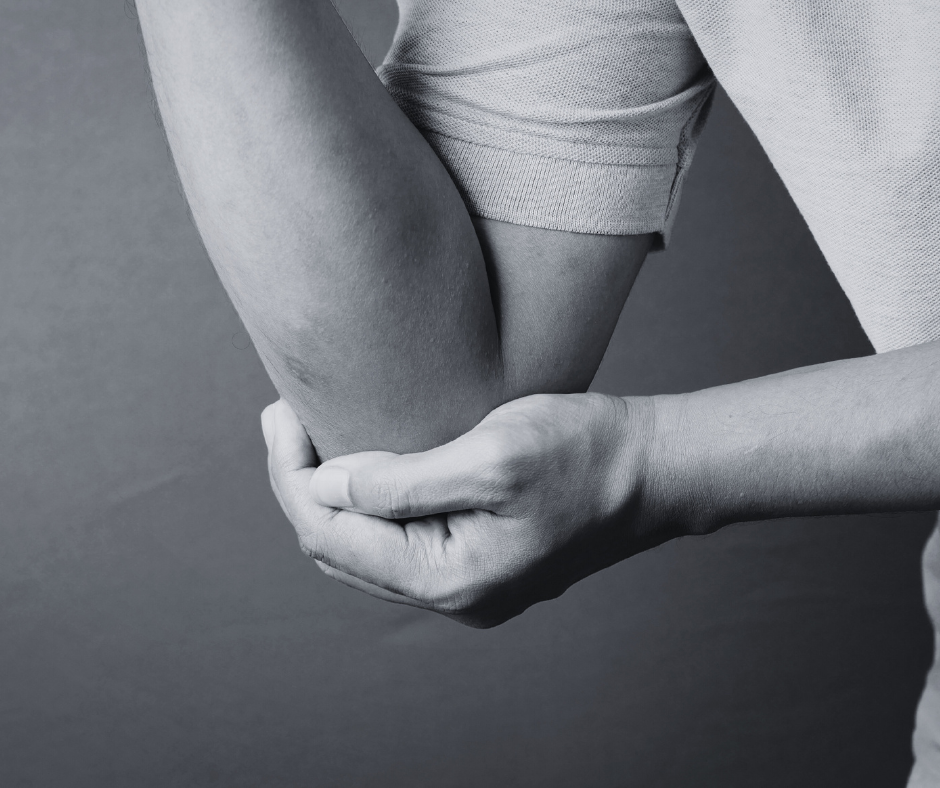 A person holding their knee, which appears to be injured or in pain, in a black and white photo.