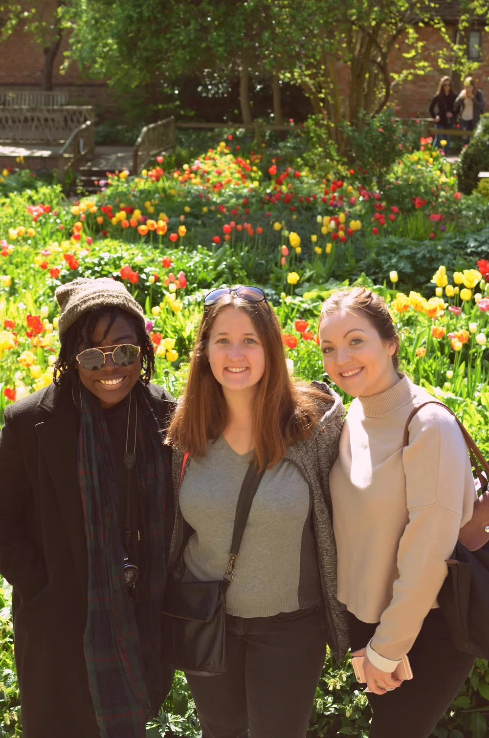 A narrow street in a historic town with a Gothic cathedral in the background, shops, and signs along the street.
