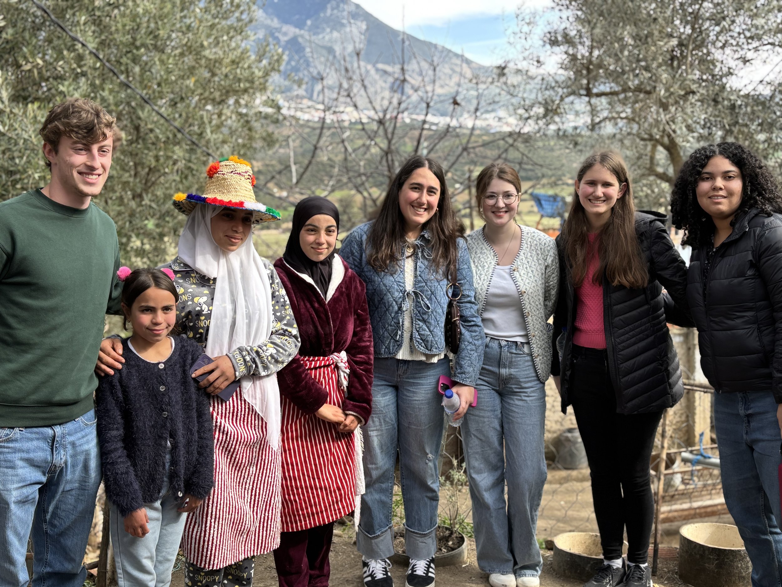 A variety of spices and herbs in bowls and containers at a market, including yellow, orange, red, and brown powders, dried herbs, and a blue spice.