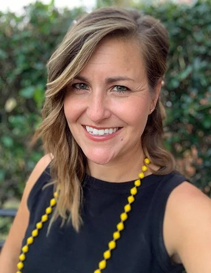 Headshot of a  woman with wavy, shoulder-length hair.