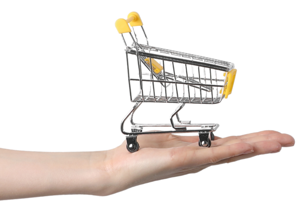 Small shopping cart placed on hand representing e-commerce, online shopping, or retail concept.